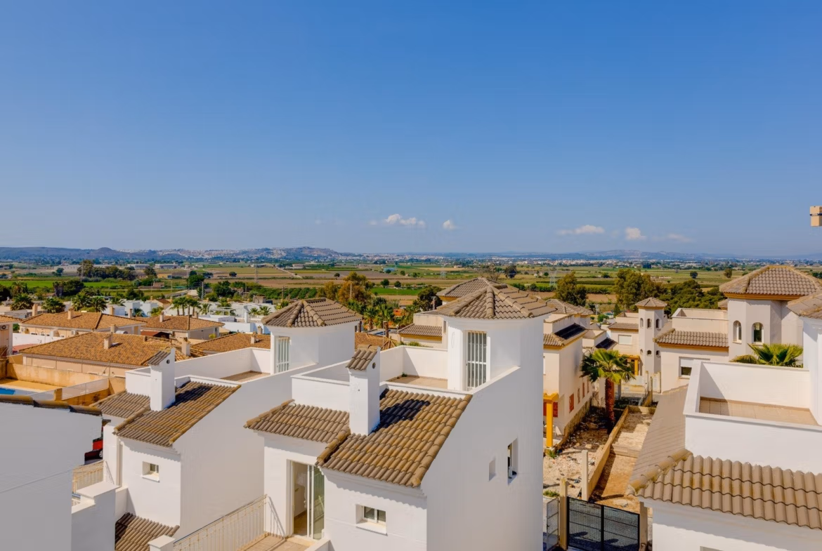 Sunlit exterior view of modern 3 bedroom villas with tiled roofs surrounded by landscaped gardens in El Oasis, San Fulgencio.