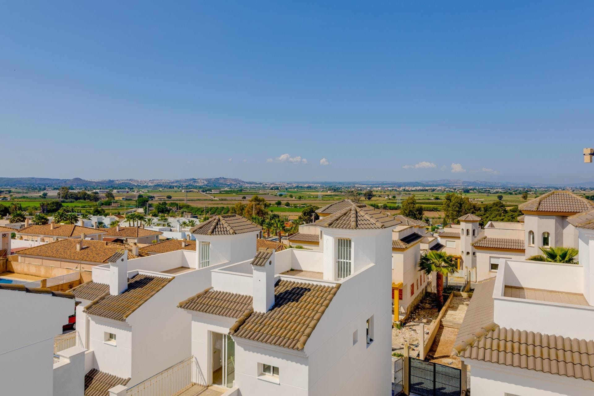 NEW-BUILD-RESIDENTIAL-IN-SAN-FULGENCIO-34 Sunlit exterior view of modern 3 bedroom villas with tiled roofs surrounded by landscaped gardens in El Oasis, San Fulgencio.