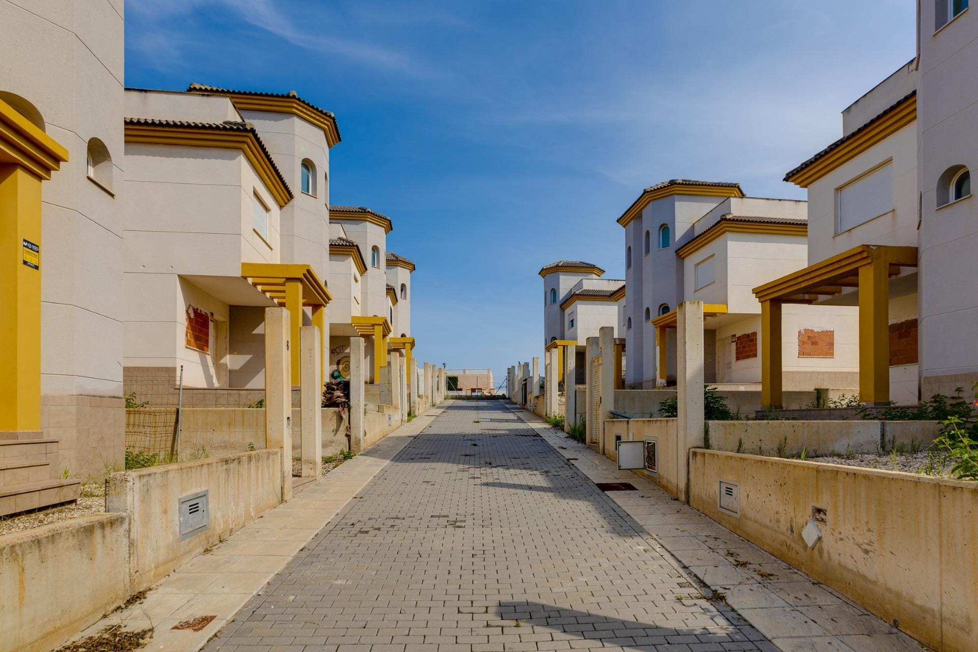 NEW-BUILD-RESIDENTIAL-IN-SAN-FULGENCIO-36 Sunlit exterior of elegant 3-bedroom villas with private terraces in a serene El Oasis, San Fulgencio neighborhood.