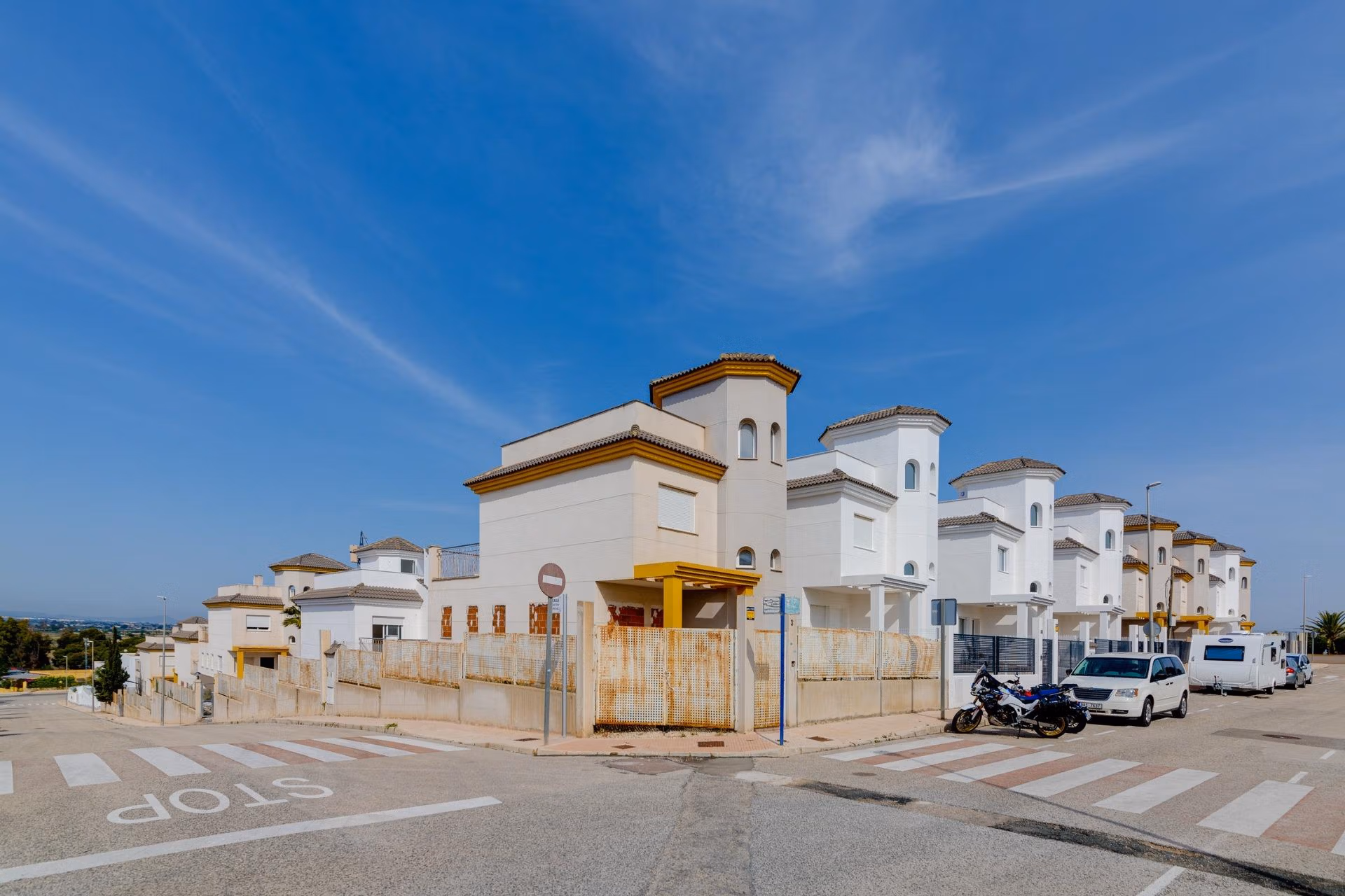 NEW-BUILD-RESIDENTIAL-IN-SAN-FULGENCIO-41 Bright, elegant 2-bedroom semi-detached villa in El Oasis La Marina Urbanisation with modern exterior and clear blue sky backdrop.