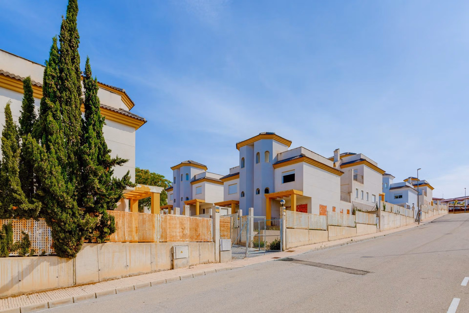 NEW-BUILD-RESIDENTIAL-IN-SAN-FULGENCIO-42 Sunlit exterior view of elegant 2 bedroom semi-detached villas in the serene El Oasis La Marina urbanisation.