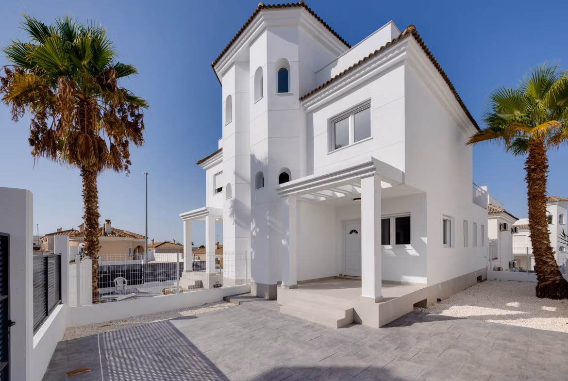 Elegante witte villa met 3 slaapkamers, ruim terras en een door palmen omlijnde buitenruimte in het zonnige El Oasis, San Fulgencio.