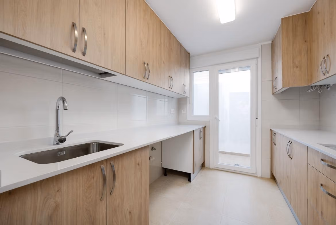 Modern, bright kitchen with sleek wood cabinetry in a key ready 3 bedroom villa in El Oasis, San Fulgencio