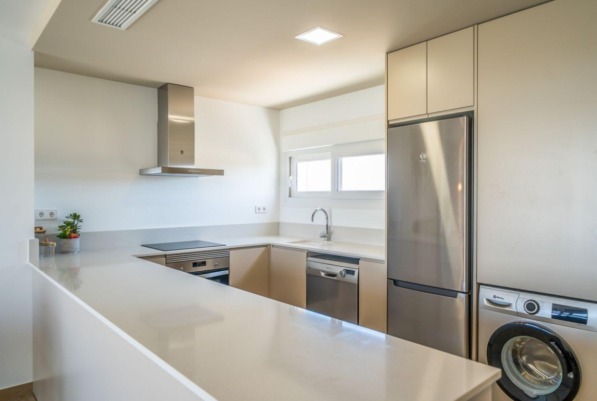 Bright modern kitchen with sleek appliances and clean lines in a 2 bedroom townhouse at Vistabella Golf, Orihuela.