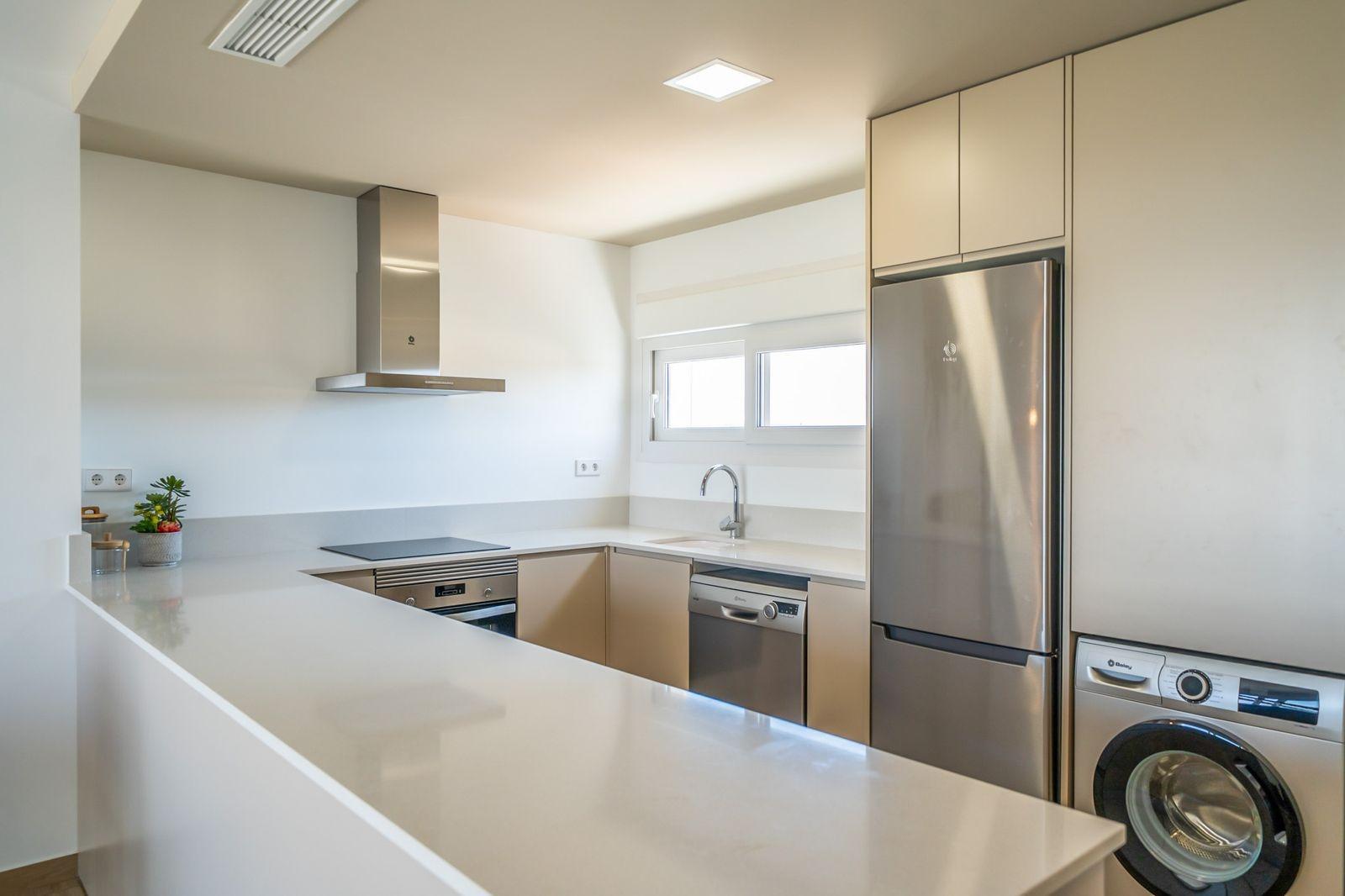 Bright modern kitchen with sleek appliances and clean lines in a 2 bedroom townhouse at Vistabella Golf, Orihuela.