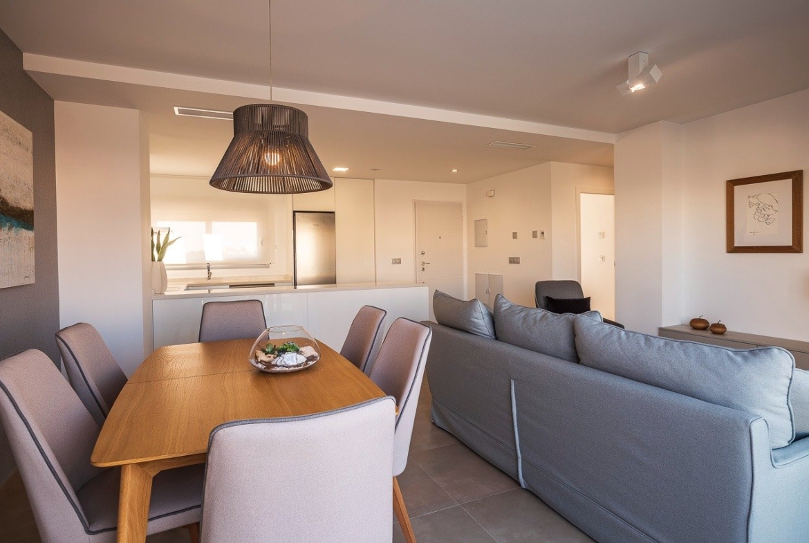 Bright open-plan living and dining area with modern kitchen in 2-bedroom top floor apartment at Vistabella Golf, Orihuela.