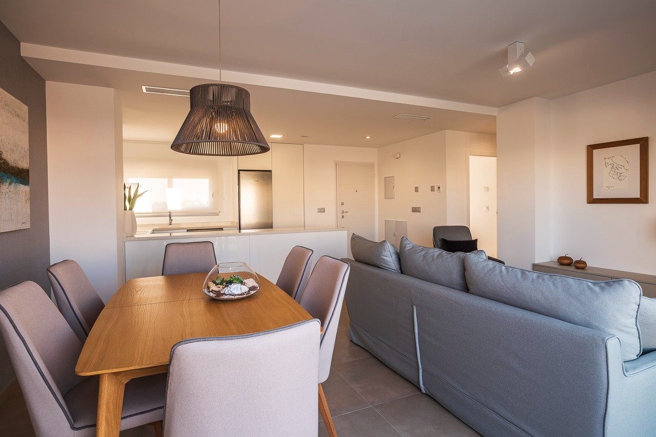 Bright open-plan living and dining area with modern kitchen in 2-bedroom top floor apartment at Vistabella Golf, Orihuela.