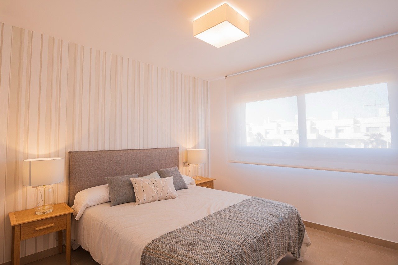 Bright and elegant 2-bedroom top floor apartment bedroom in Vistabella Golf, Orihuela with soft lighting and modern decor.