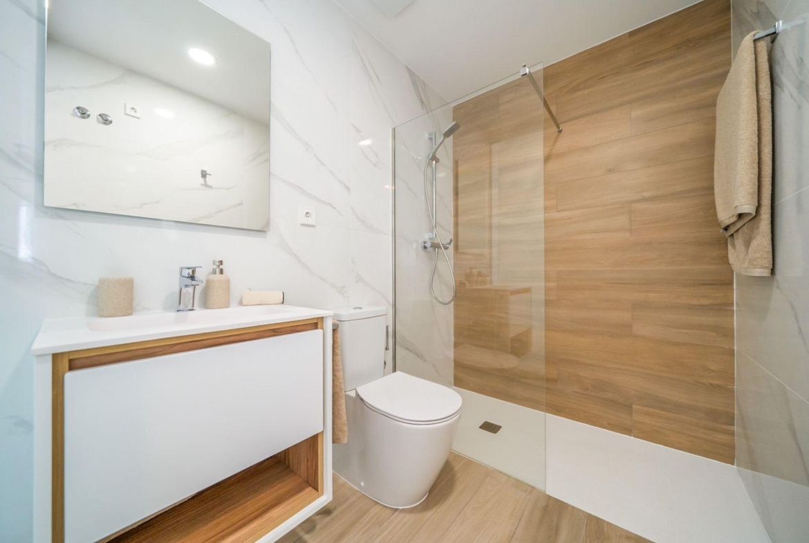 Bright modern bathroom with sleek wooden shower wall and minimalist fixtures in a 2-bedroom top floor bungalow, Vistabella Golf Orihuela