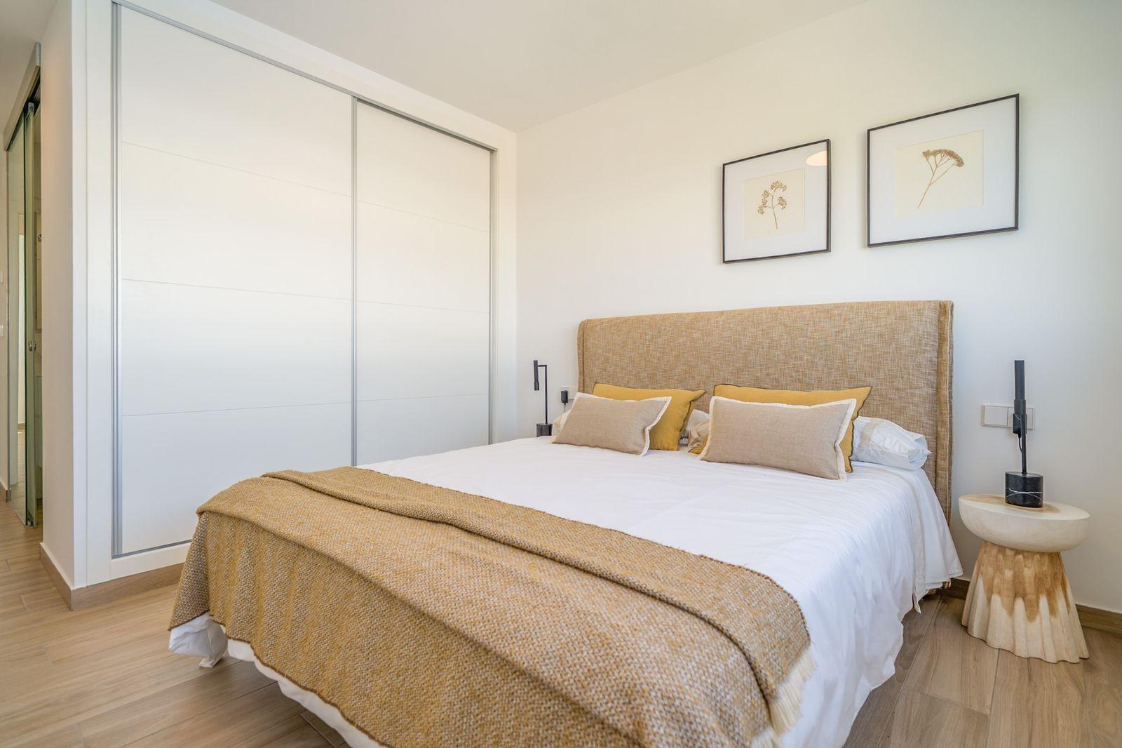 Bright and modern 2-bedroom townhouse bedroom with natural tones and sleek built-in wardrobe in Vistabella Golf, Orihuela.
