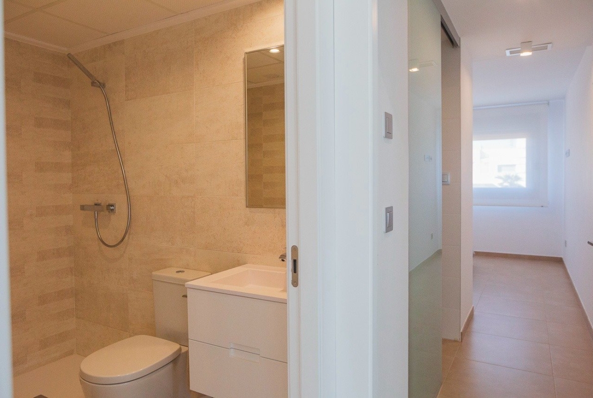 Bright modern bathroom and minimalist hallway in a key ready 2-bedroom top floor apartment in Vistabella Golf, Orihuela.