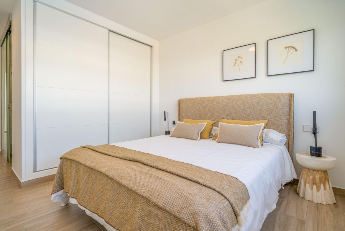 Bright and modern 2-bedroom top floor bungalow bedroom with cozy textiles and minimalist decor in Vistabella Golf, Orihuela.