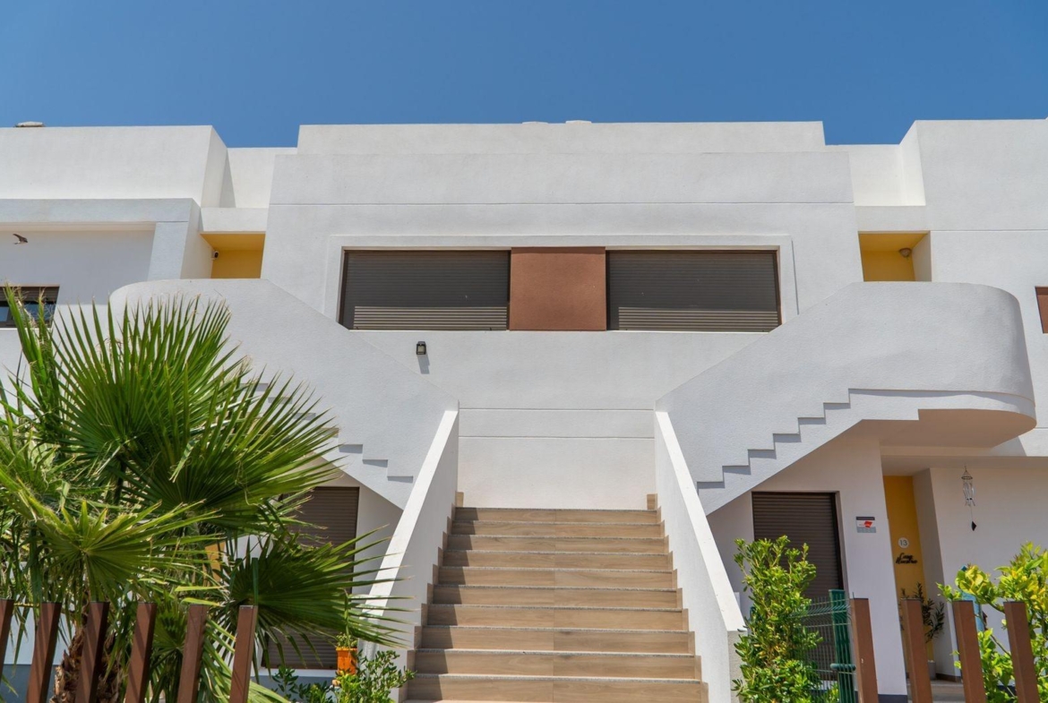 Bright modern top floor bungalow with sleek staircase and lush landscaping in Vistabella Golf, Orihuela.