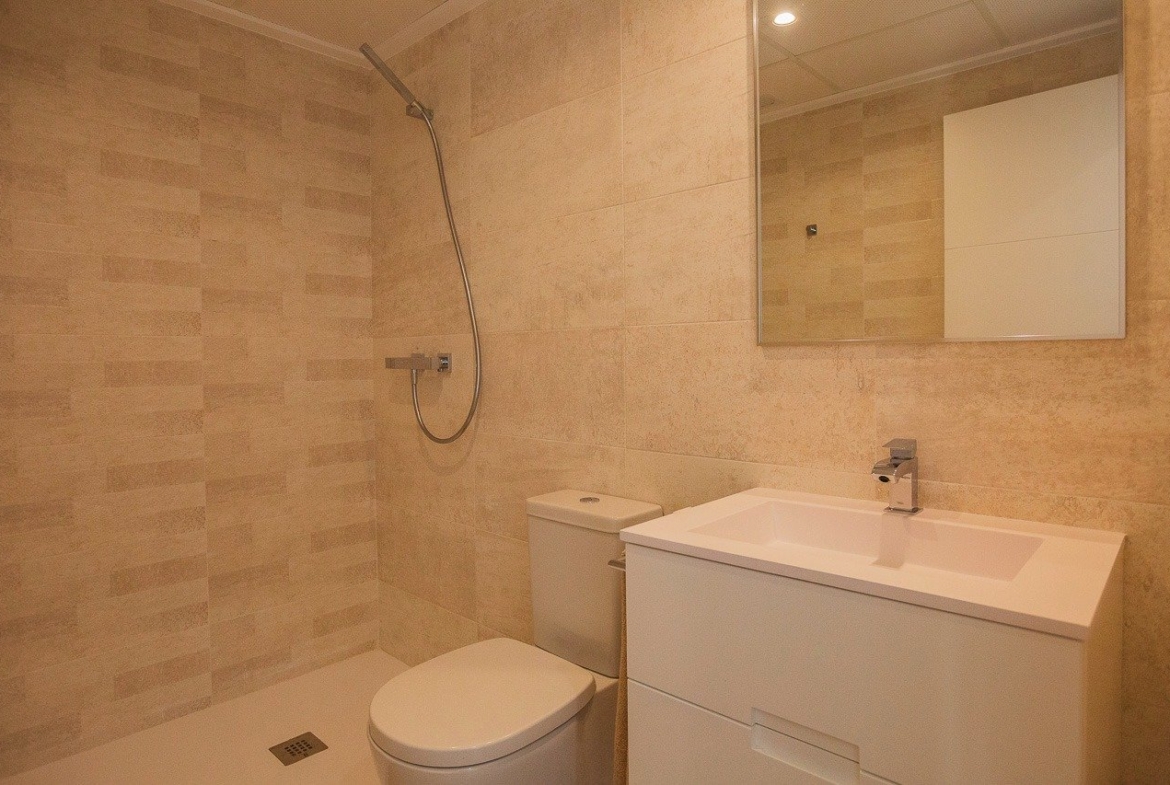 Modern, bright bathroom with sleek fixtures in a key ready 2 bedroom top floor apartment at Vistabella Golf, Orihuela.