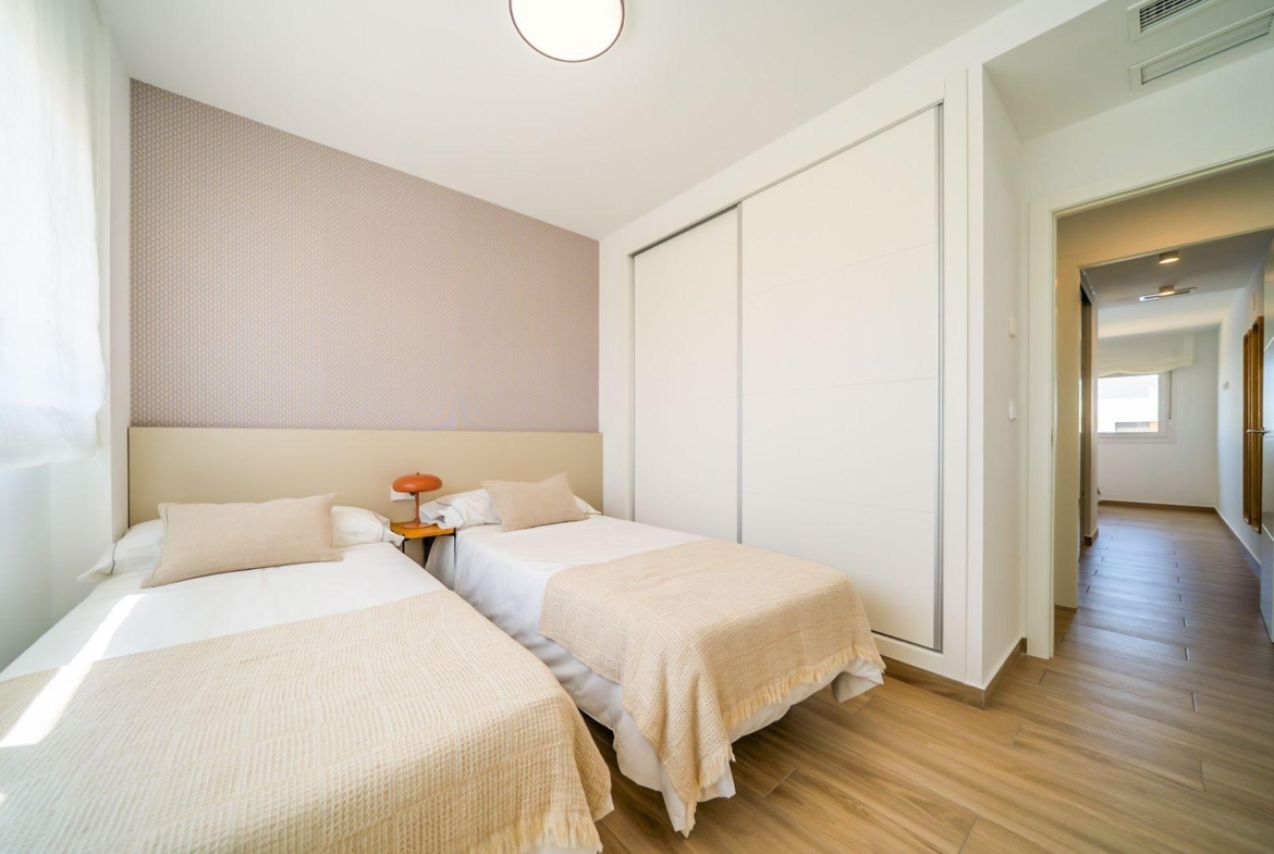 Bright modern twin bedroom with soft neutral tones and sleek built-in wardrobes in top floor bungalow, Vistabella Golf Orihuela