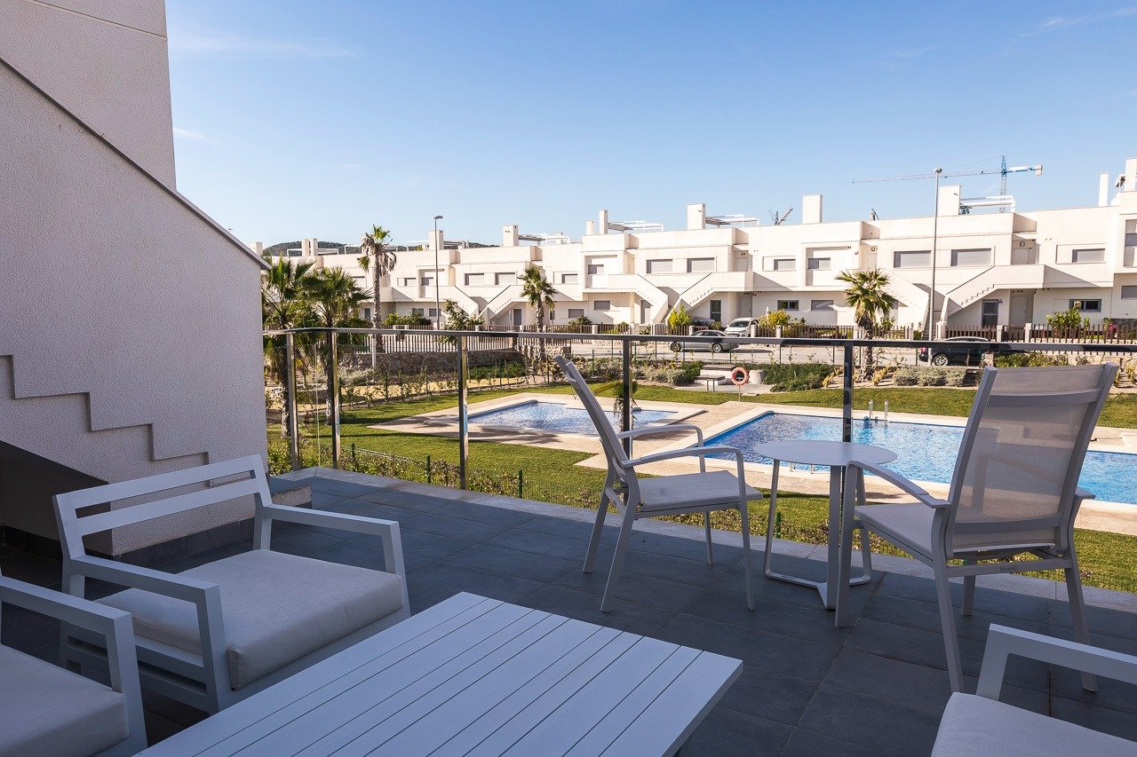 Spacious terrace overlooking the pristine pool and landscaped gardens in a modern 2-bedroom top floor apartment at Vistabella Golf, Orihuela.