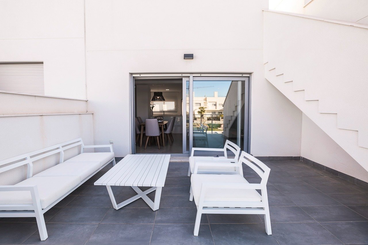 Spacious sun-drenched top floor terrace with modern white outdoor furniture in 2 bedroom apartment at Vistabella Golf, Orihuela