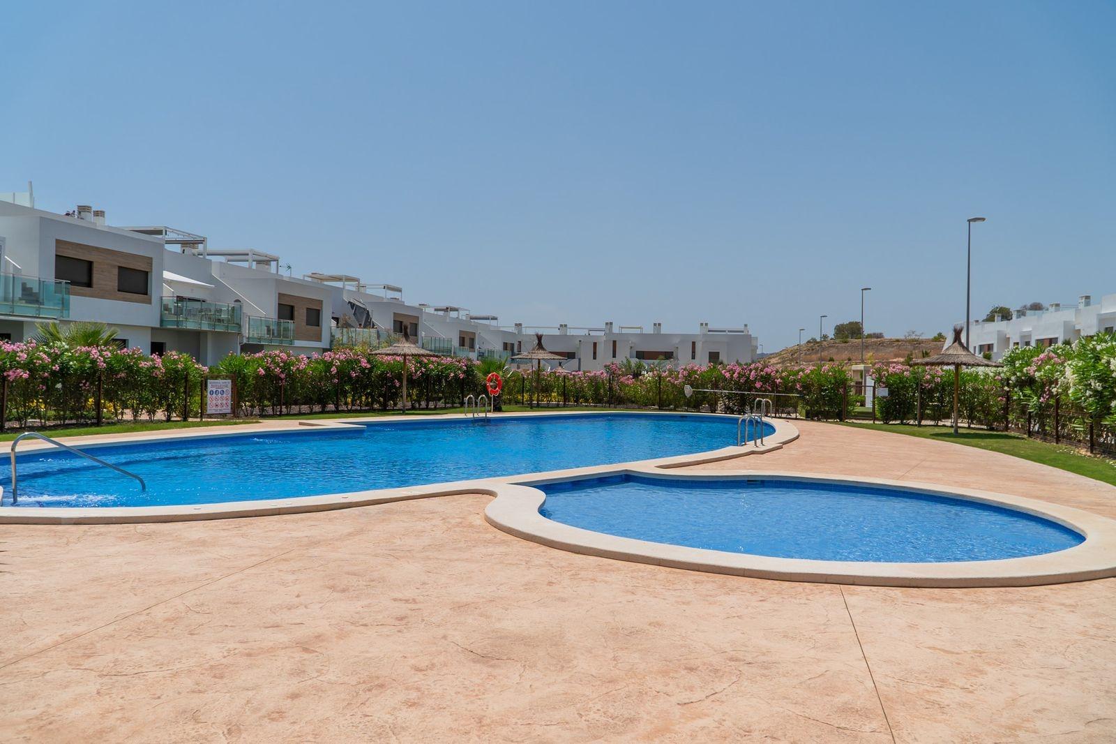 NEW-BUILD-RESIDENTIAL-OF-BUNGALOW-APARTMENTS-IN-VISTABELLA-29 Sun-drenched communal pool with landscaped gardens in front of modern 2-bedroom top floor bungalow in Vistabella Golf, Orihuela