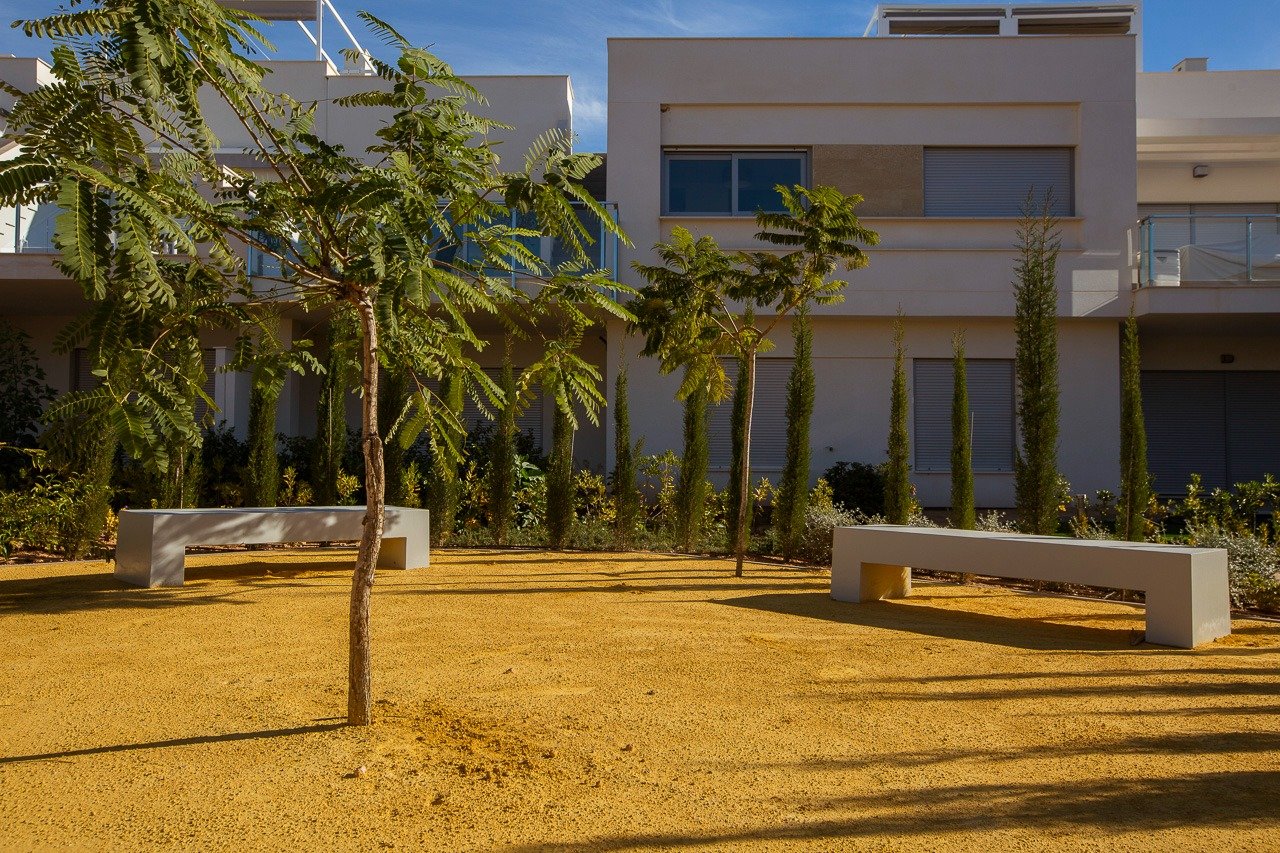 Modern key ready 2-bedroom top floor apartment exterior surrounded by landscaped greenery in Vistabella Golf, Orihuela