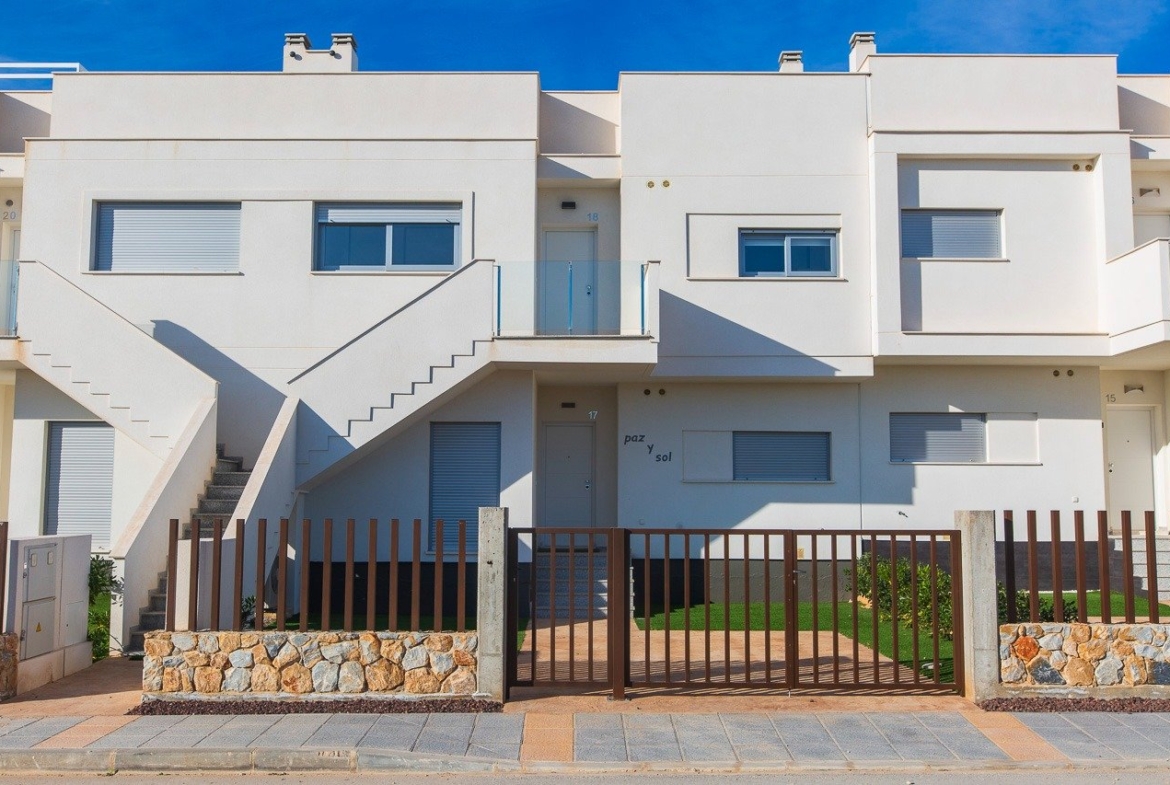 Modern white facade of top floor 2-bedroom apartment with private solarium and gated entrance in Vistabella Golf, Orihuela.