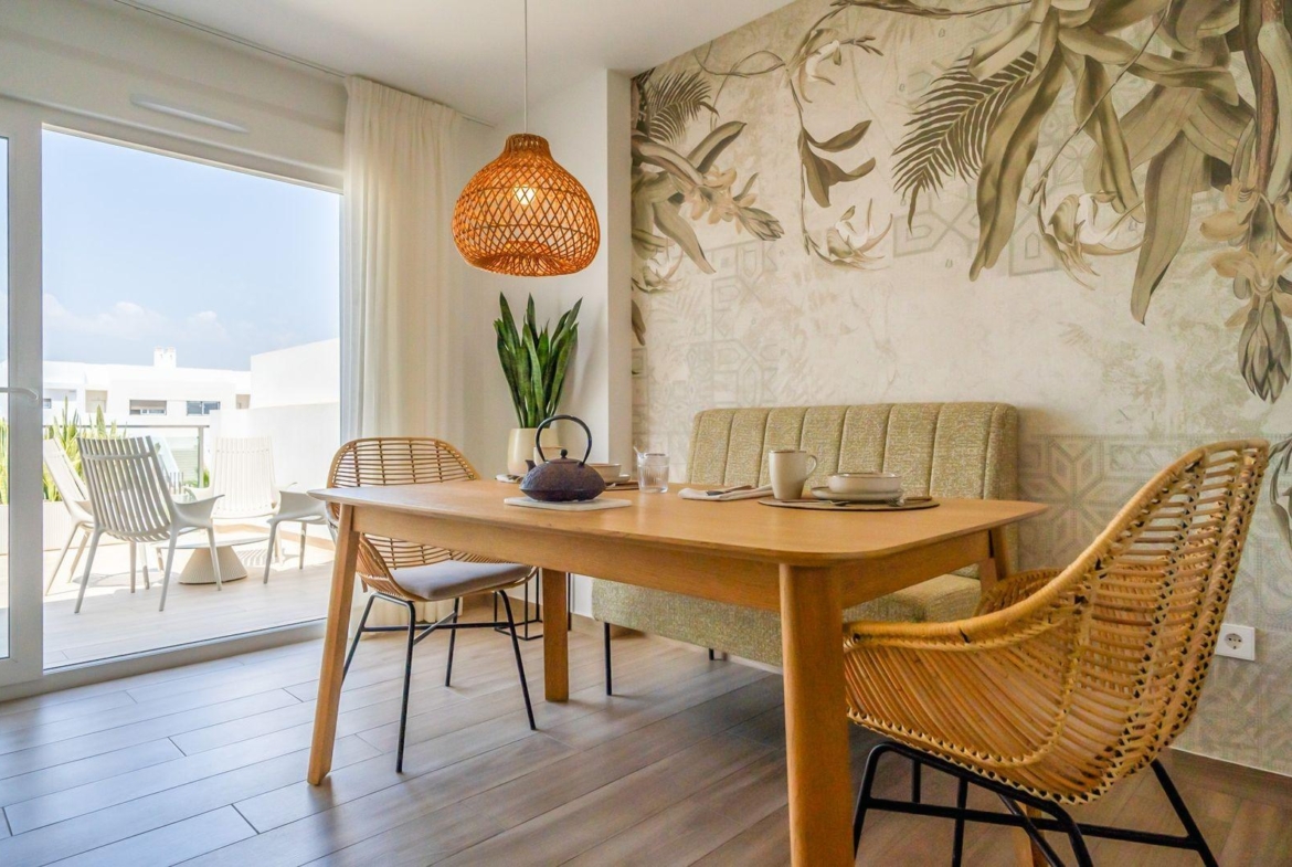 Bright dining area with wicker chairs and balcony in a modern 2-bedroom townhouse at Vistabella Golf, Orihuela