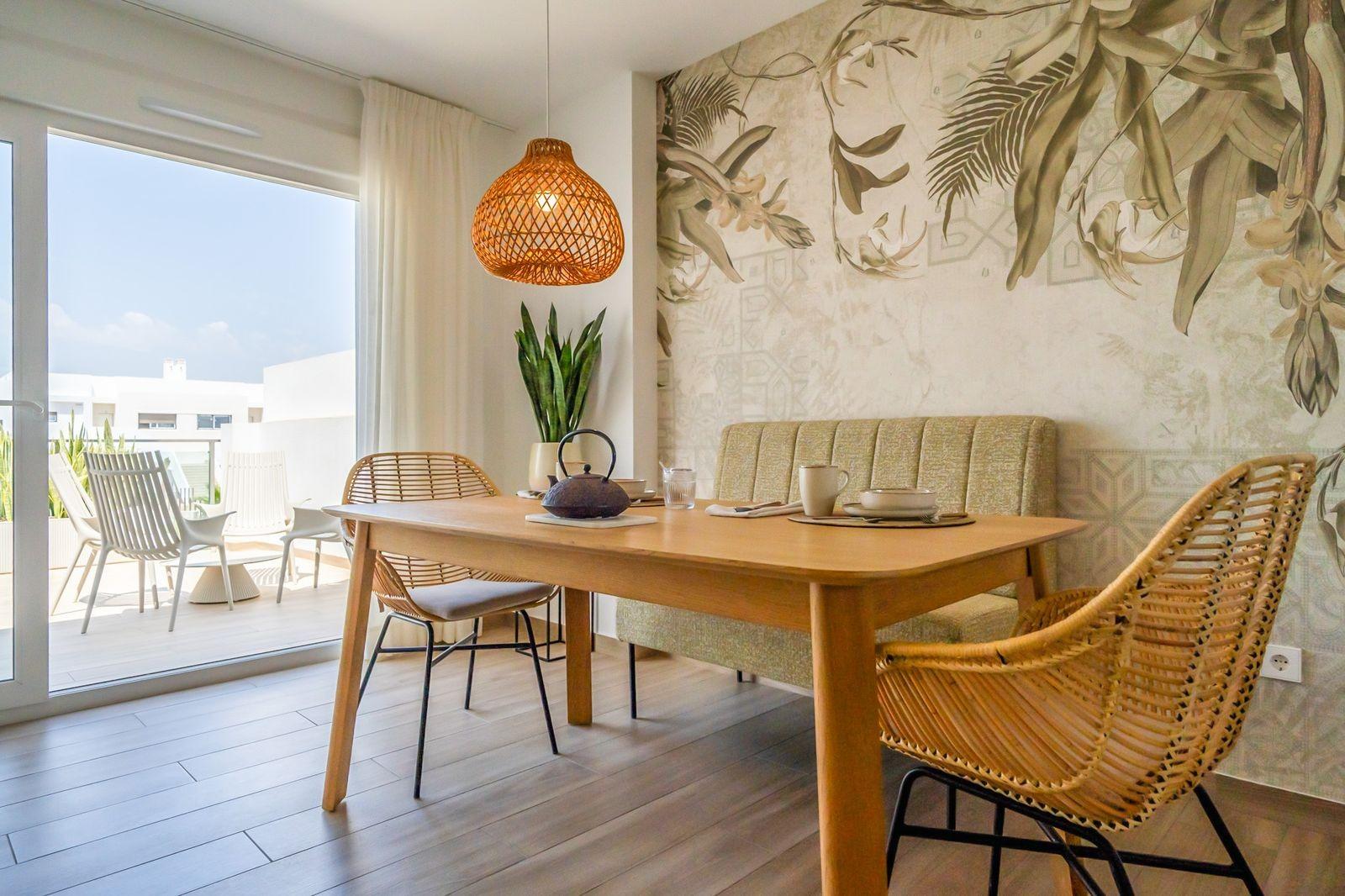 Bright dining area with wicker chairs and balcony in a modern 2-bedroom townhouse at Vistabella Golf, Orihuela