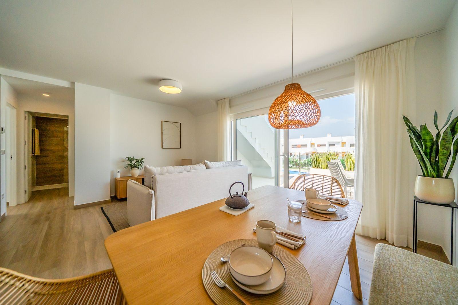 NEW-BUILD-RESIDENTIAL-OF-BUNGALOW-APARTMENTS-IN-VISTABELLA-5 Bright modern open-plan living and dining area in a 2-bedroom top floor bungalow with solarium in Vistabella Golf, Orihuela.