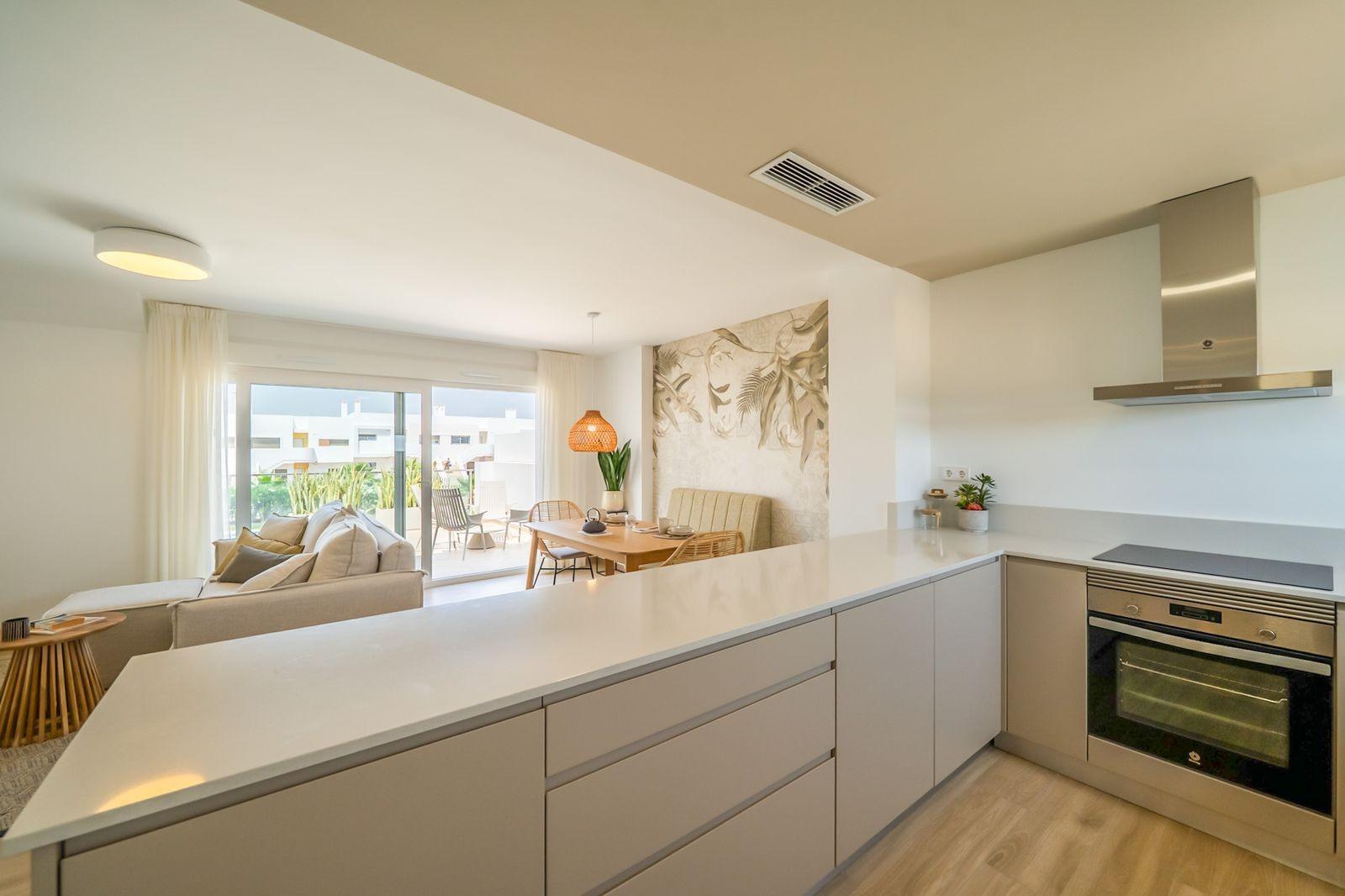 Bright modern kitchen with open-plan living and dining area in a stylish 2-bedroom townhouse at Vistabella Golf, Orihuela.