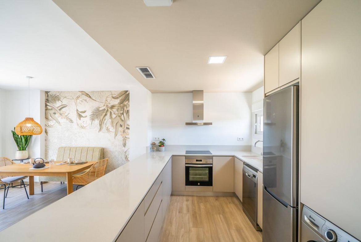 Bright modern kitchen and open dining area in a sleek 2-bedroom townhouse with garden in Vistabella Golf, Orihuela.