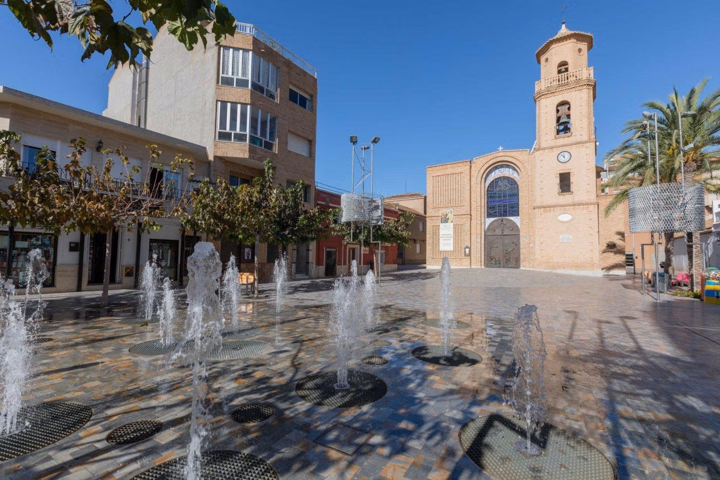 NEW-BUILD-SEMI-DETACHED-VILLAS-IN-PILAR-DE-LA-HORADADA-7 Sunlit historic square with decorative fountains and charming architecture near the new build villa in Pilar de la Horadada.