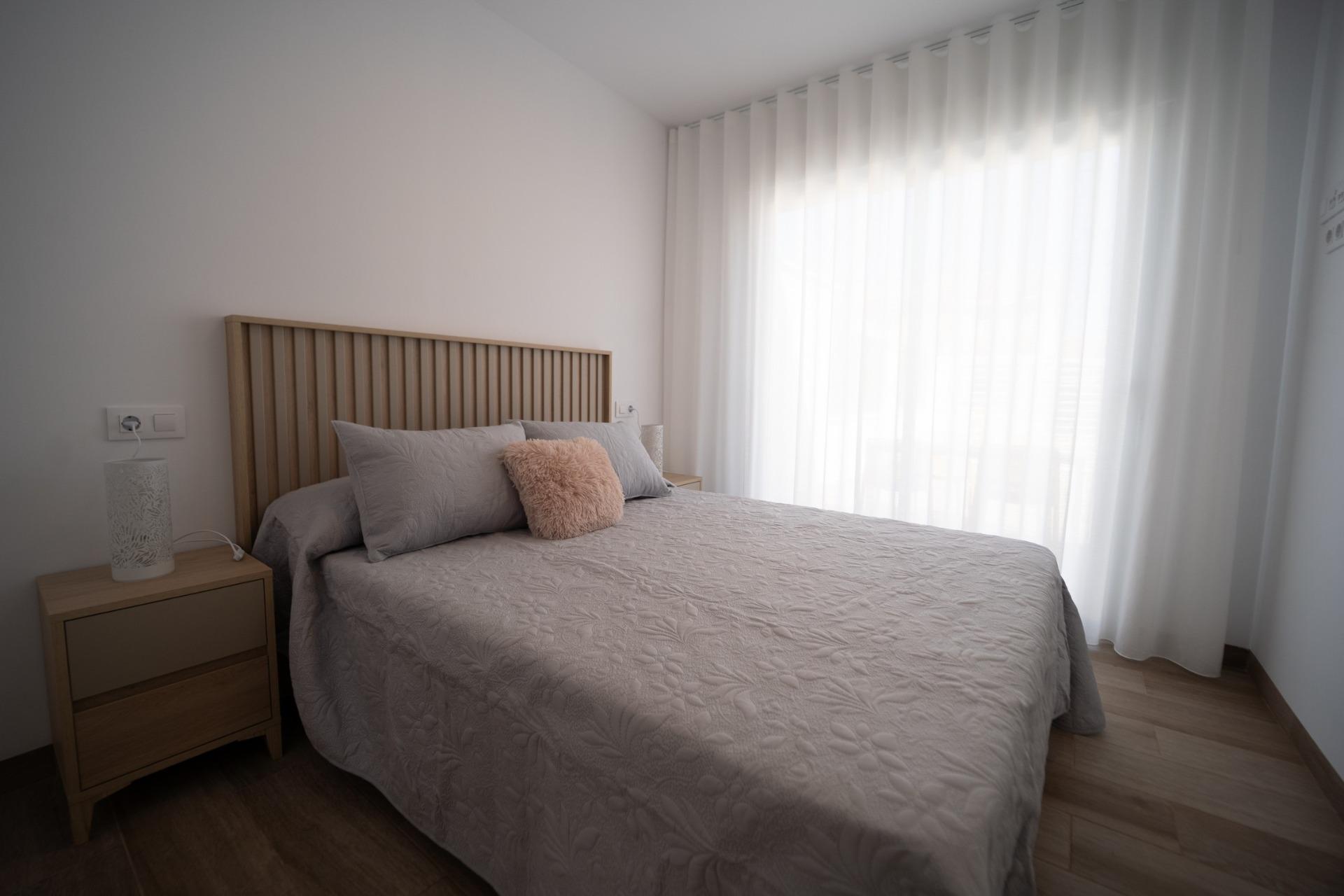 NEW-BUILD-TOWNHOUSES-IN-SAN-JAVIER-13 Bright and serene bedroom with soft textiles and wooden accents in new build townhouses in San Javier