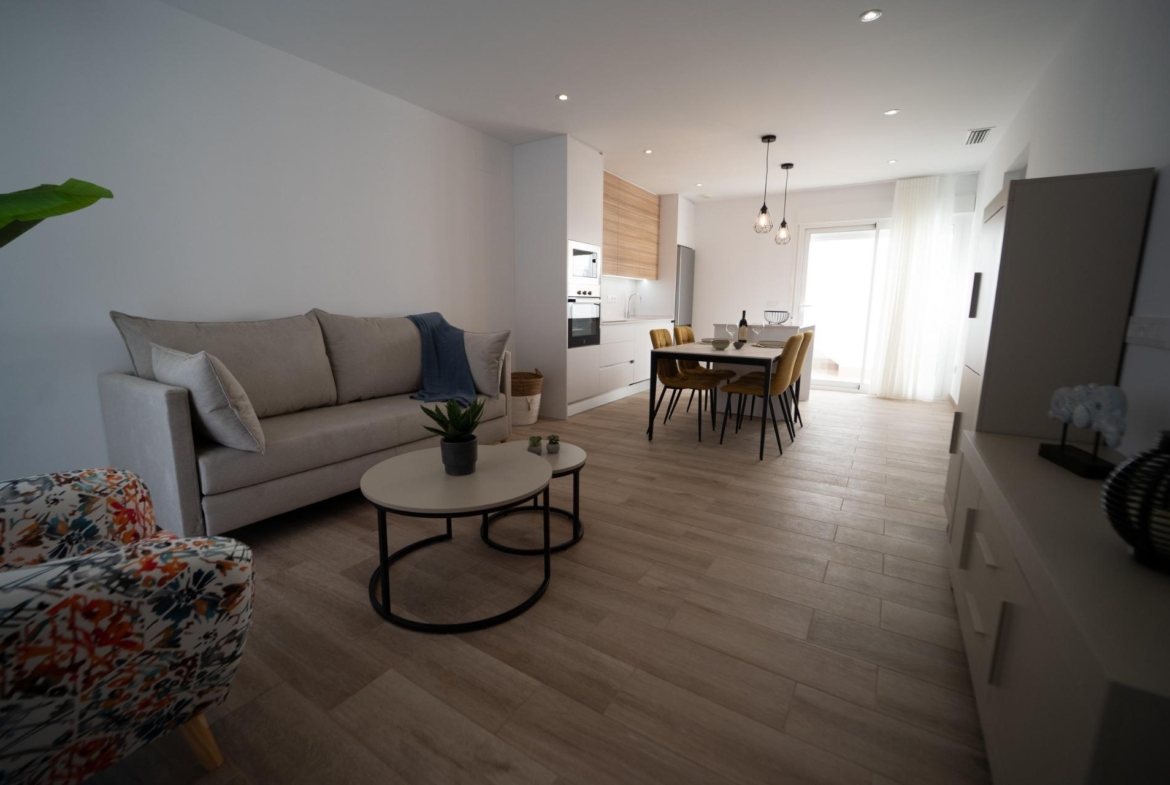 Bright open-plan living and dining area with modern kitchen in new build townhouses in San Javier.