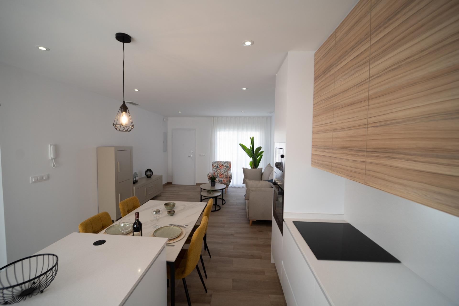 NEW-BUILD-TOWNHOUSES-IN-SAN-JAVIER-15 Bright modern open-plan kitchen and dining area with elegant wood finishes in new build townhouses in San Javier