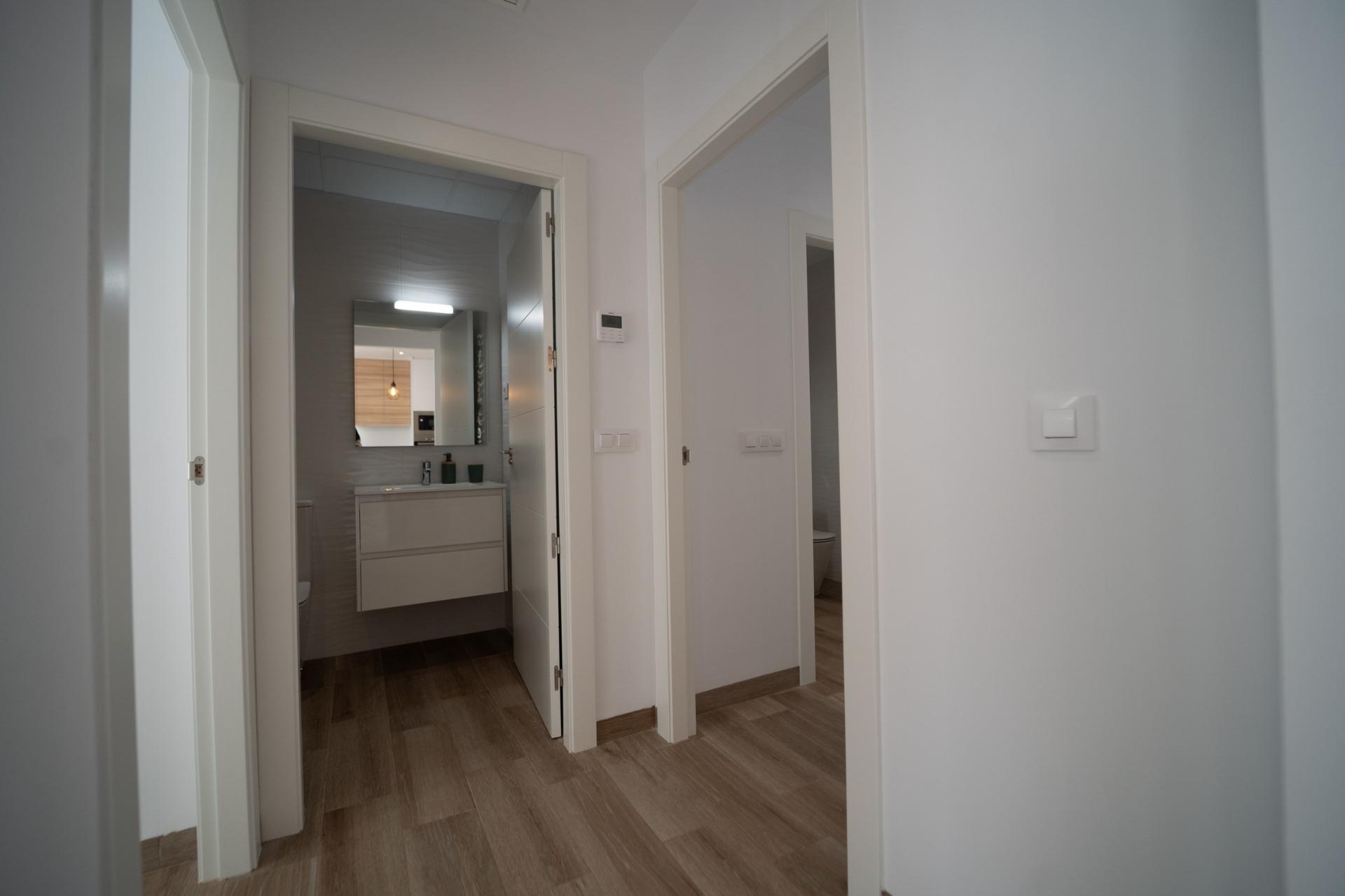 NEW-BUILD-TOWNHOUSES-IN-SAN-JAVIER-28 Bright modern bathroom with sleek fixtures and warm wood flooring in new build townhouses in San Javier hallway