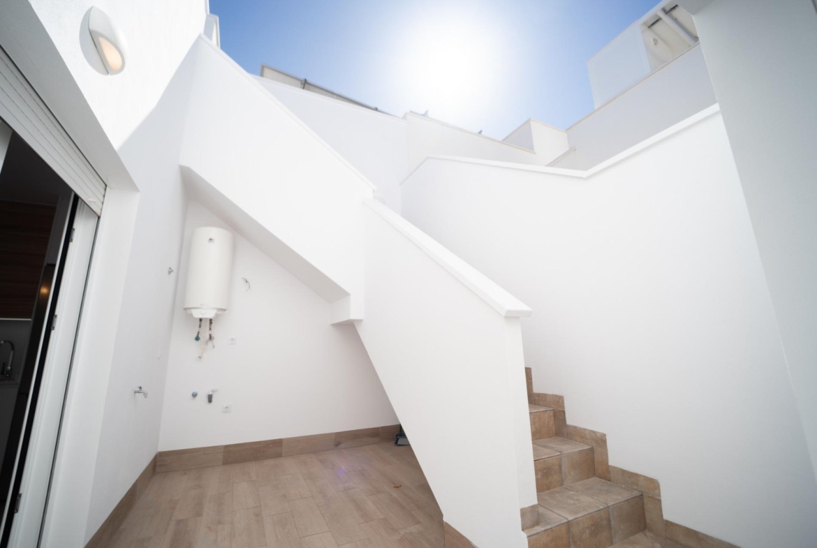 Bright, modern exterior terrace with tiled staircase and sunlit white walls in new build townhouses in San Javier