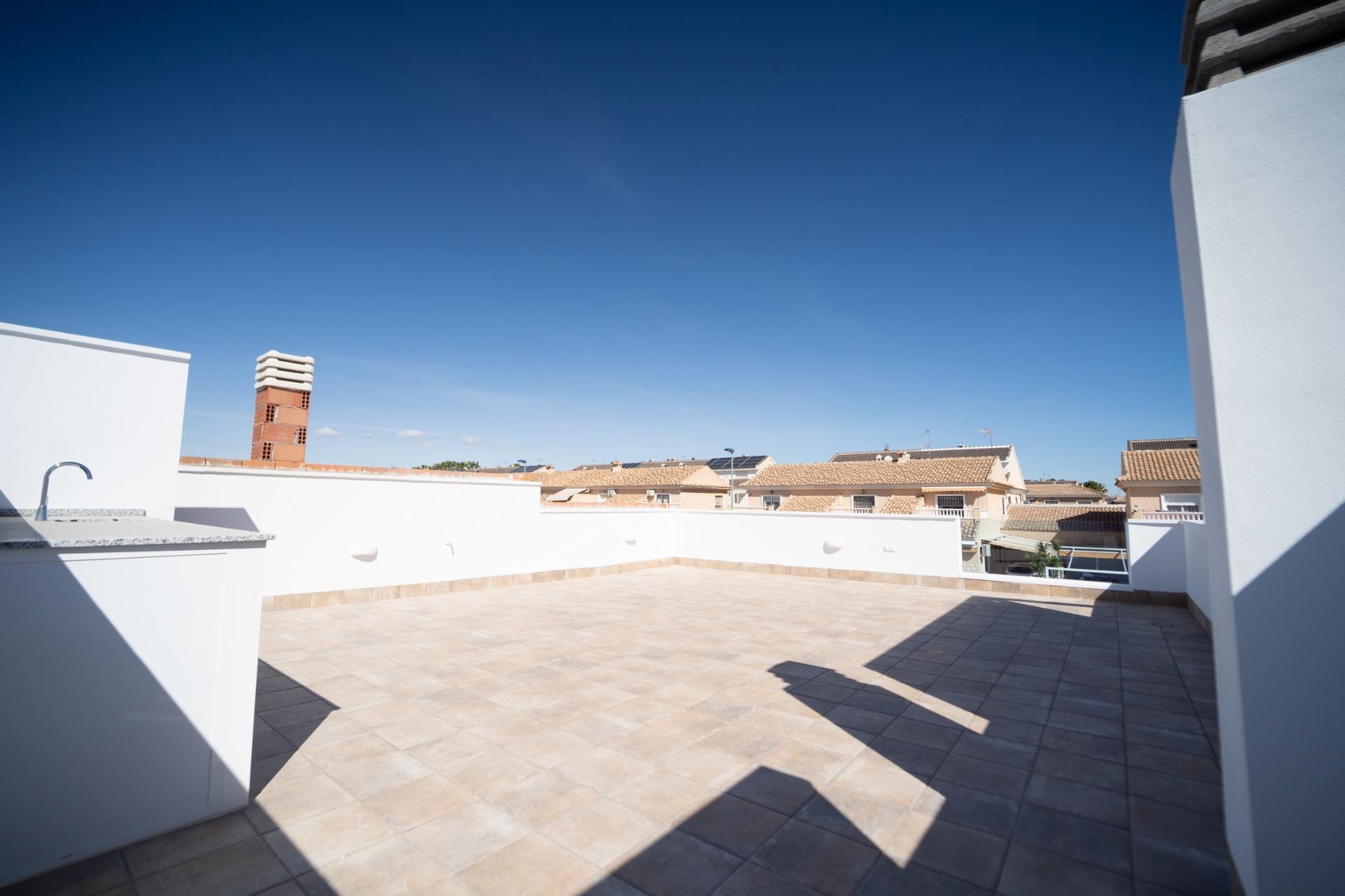 NEW-BUILD-TOWNHOUSES-IN-SAN-JAVIER-30 Spacious sun-drenched terrace with modern outdoor sink in new build townhouses in San Javier under clear blue sky