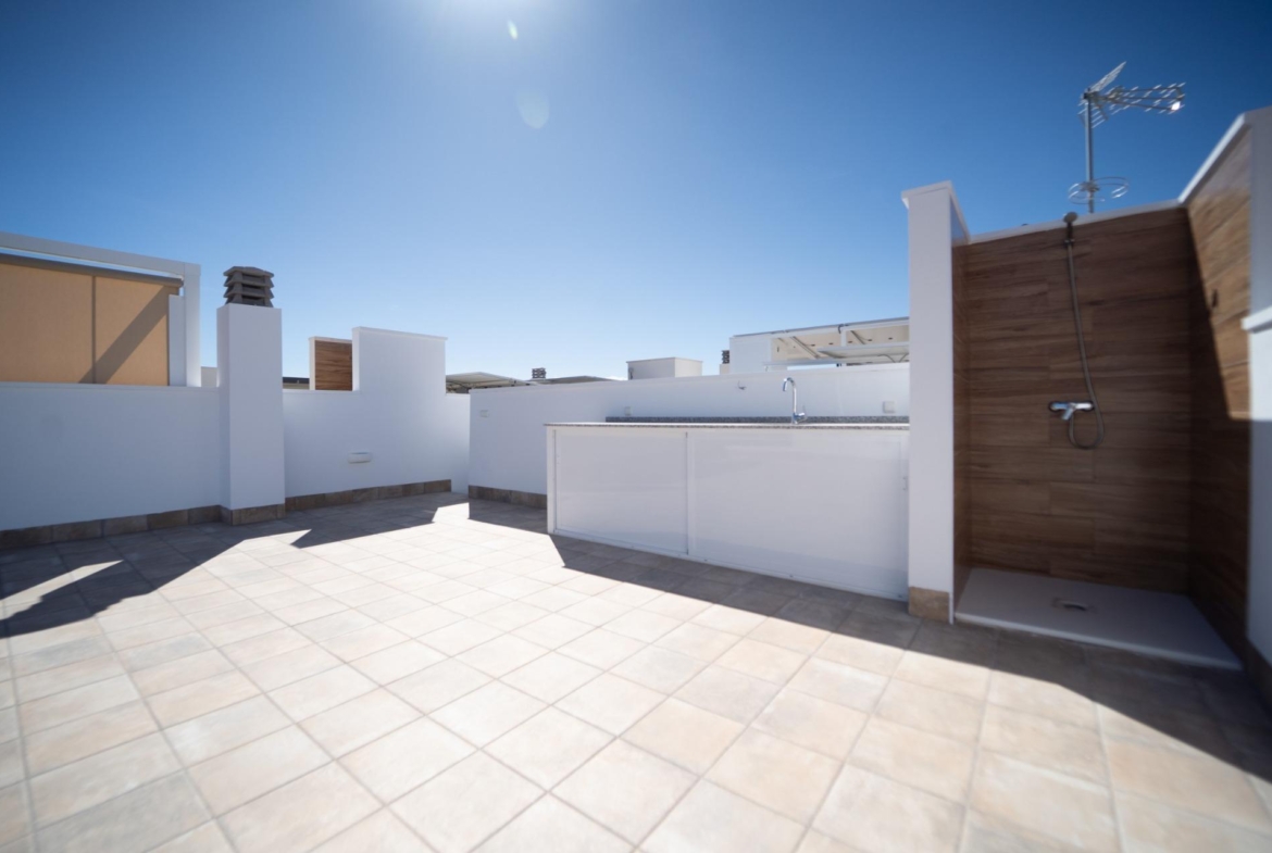 Spacious sun-drenched terrace with outdoor shower and sleek kitchenette in modern new build townhouses in San Javier