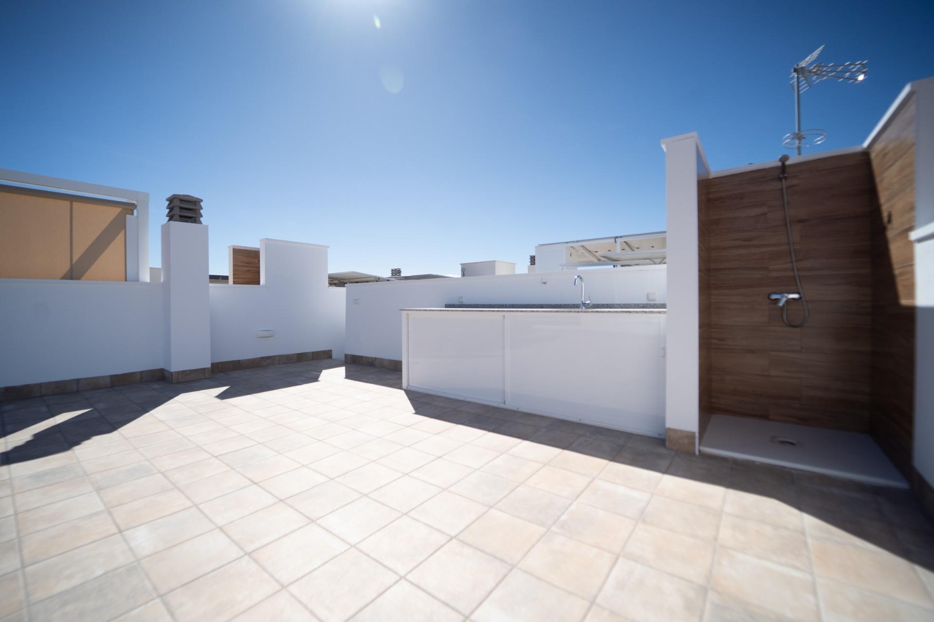 NEW-BUILD-TOWNHOUSES-IN-SAN-JAVIER-31 Spacious sun-drenched terrace with outdoor shower and sleek kitchenette in modern new build townhouses in San Javier