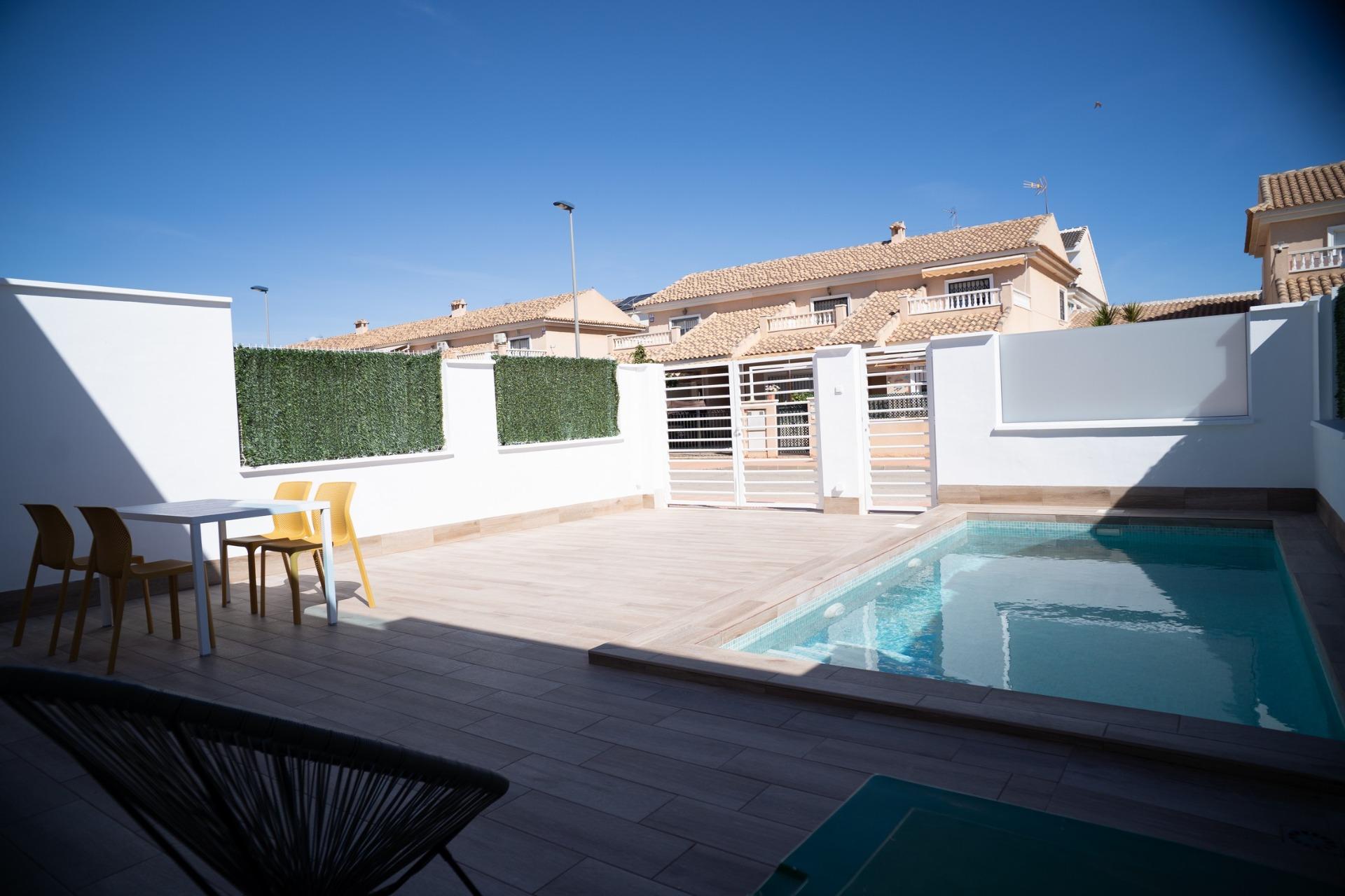 NEW-BUILD-TOWNHOUSES-IN-SAN-JAVIER-5 Sun-drenched private terrace with modern pool and sleek outdoor dining area in new build townhouses in San Javier