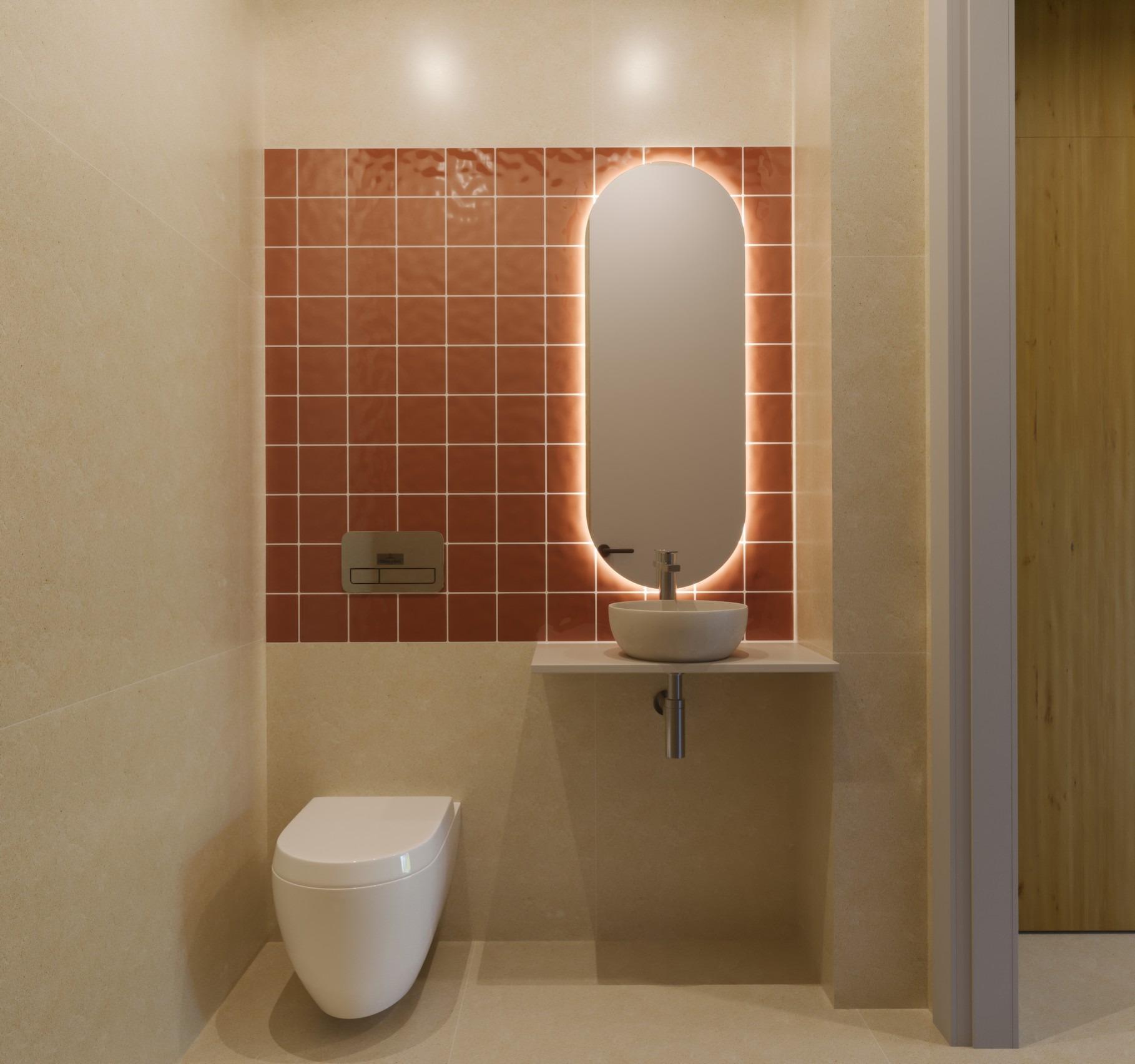 Modern guest bathroom with warm terracotta tiles and illuminated oval mirror in luxury 3-bedroom villa, Sierra Cortina Finestrat