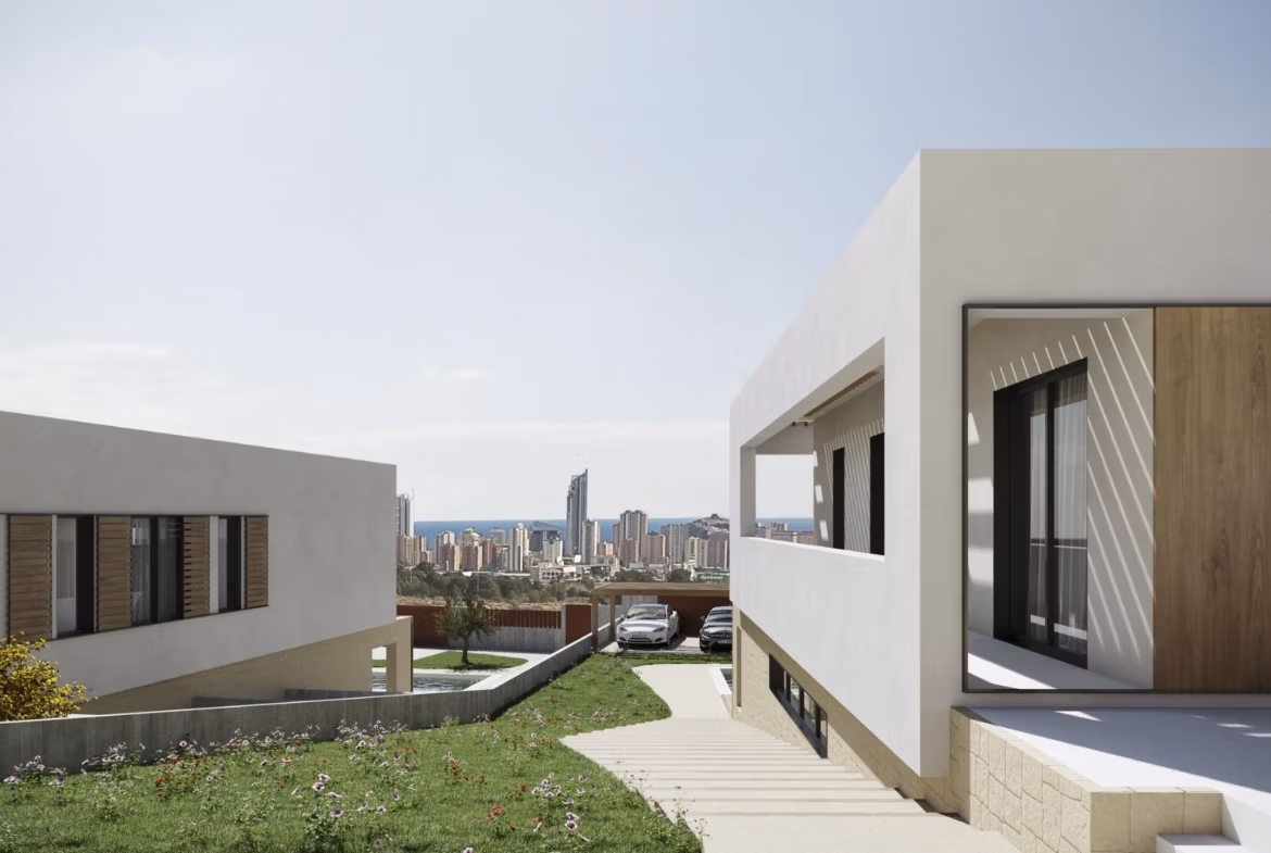 NEW-BUILD-VILLAS-IN-FINESTRAT-8 Modern luxury villa exterior in Finestrat with private terrace, landscaped garden, and panoramic sea views of Benidorm skyline.