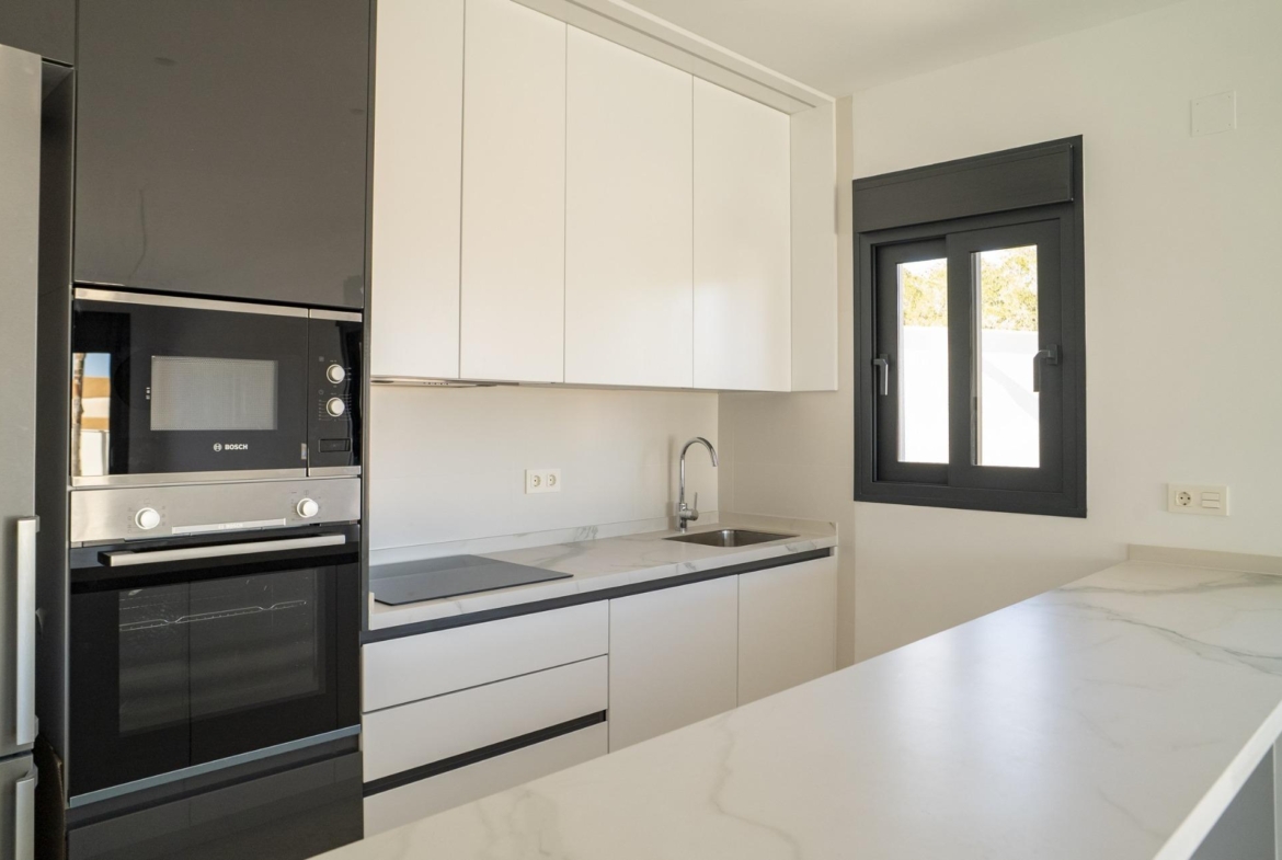 Bright modern kitchen with sleek appliances and marble countertops in a 3-bedroom villa in La Nucia, Costa Blanca.