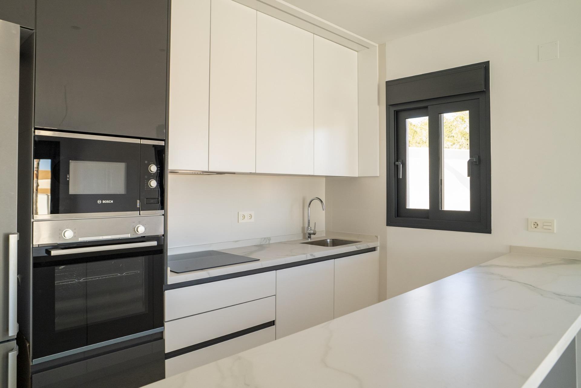 Bright modern kitchen with sleek appliances and marble countertops in a 3-bedroom villa in La Nucia, Costa Blanca.
