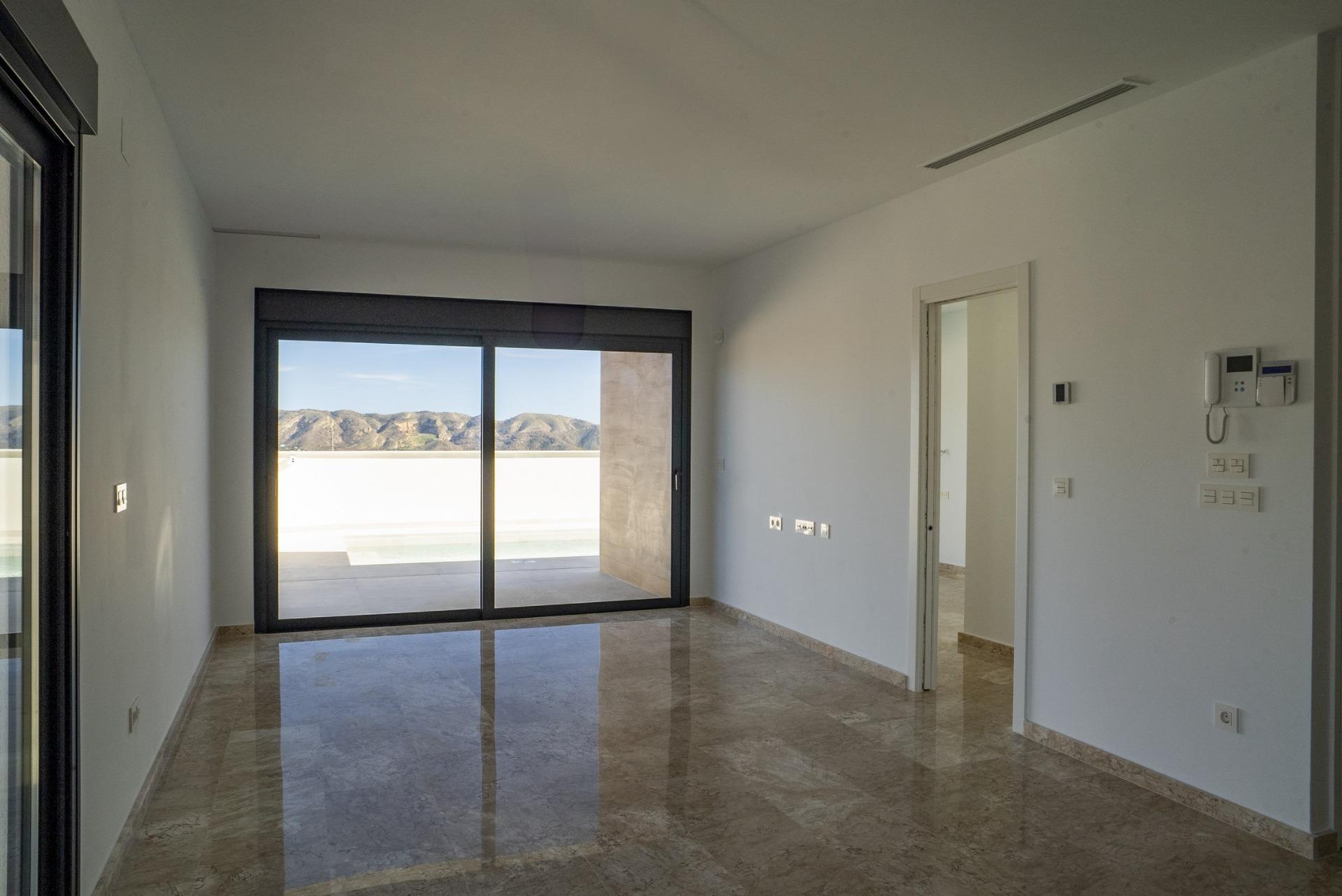 Bright modern living area with glossy floors, floor-to-ceiling windows, and stunning mountain views in La Nucia villa.