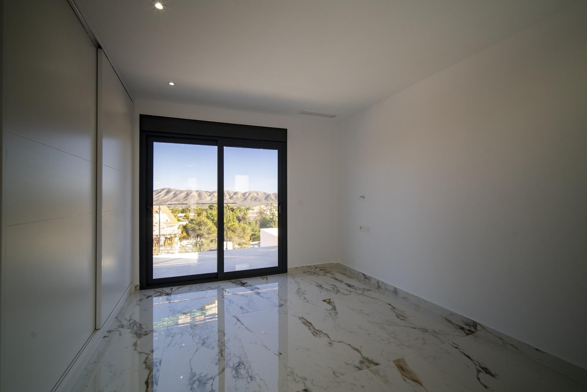 Bright modern bedroom with marble flooring and large window in new build 3 bedroom villa in La Nucia, Costa Blanca