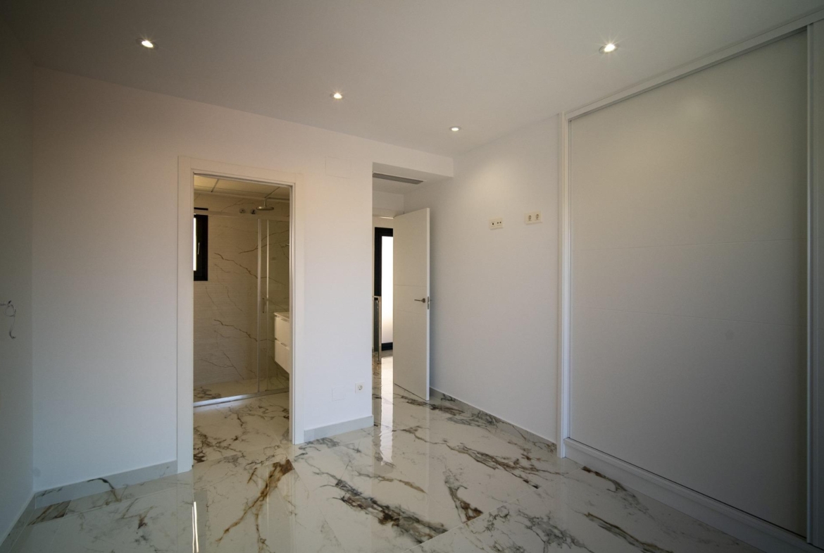 Bright modern bedroom with sleek marble flooring and minimalist design in a new 3-bedroom villa in La Nucia, Costa Blanca