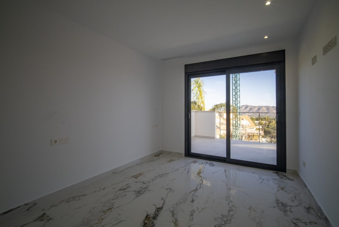 Bright modern bedroom with marble flooring and large sliding doors opening to a terrace in a new 3-bedroom villa in La Nucia, Costa Blanca