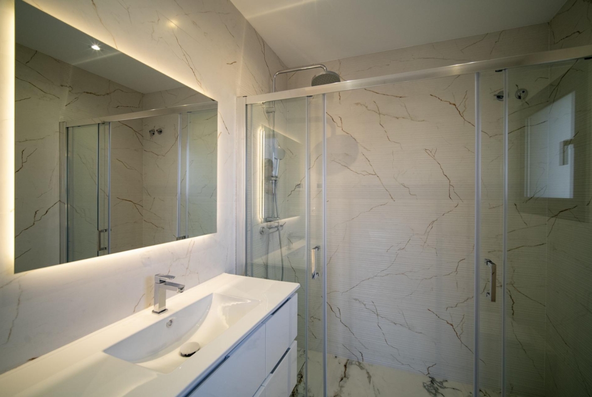 Bright modern bathroom with sleek fixtures and elegant marble walls in a 3-bedroom villa in La Nucia, Costa Blanca.