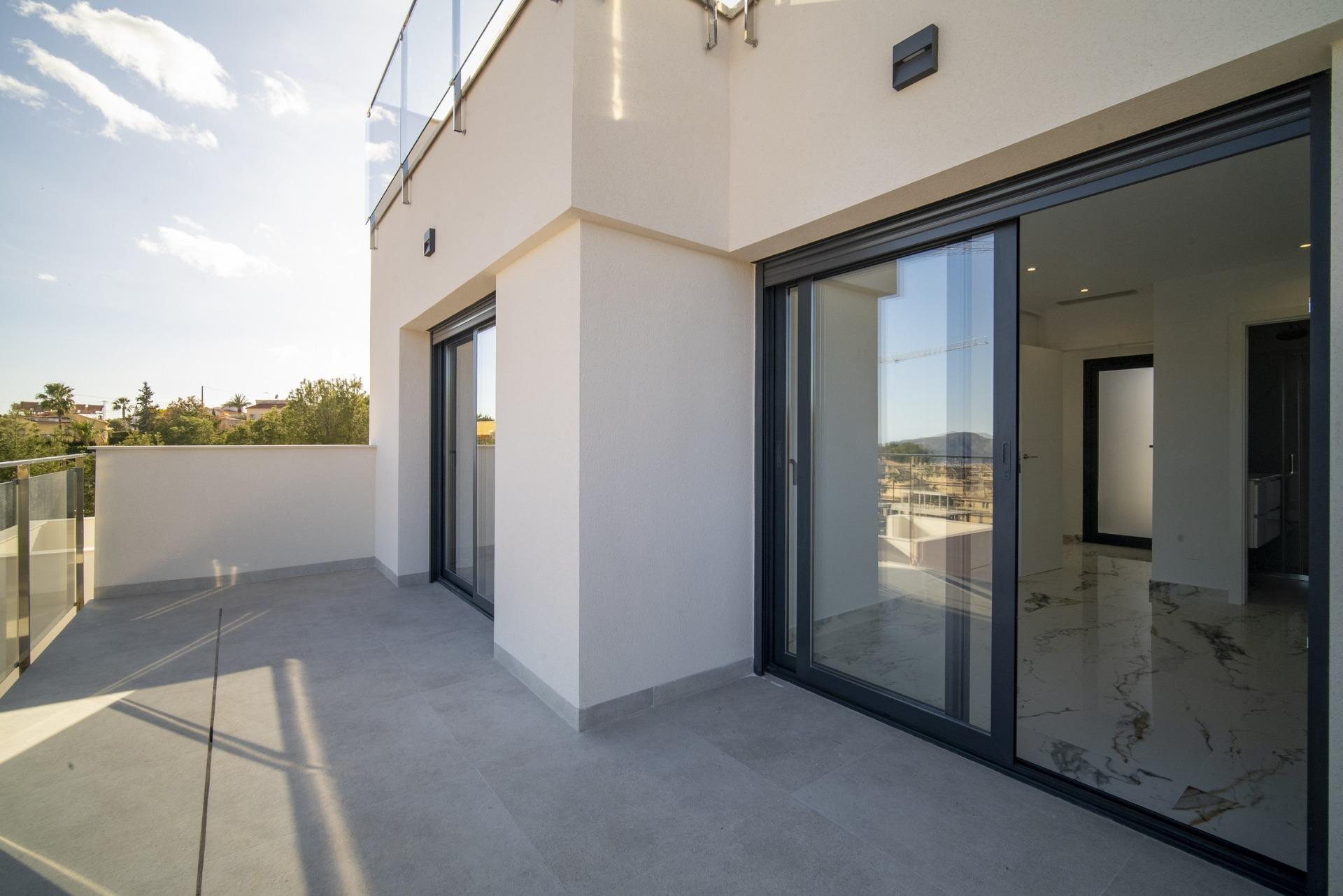 Spacious sun-drenched terrace with sleek glass doors in modern 3-bedroom villa for sale in La Nucia, Costa Blanca