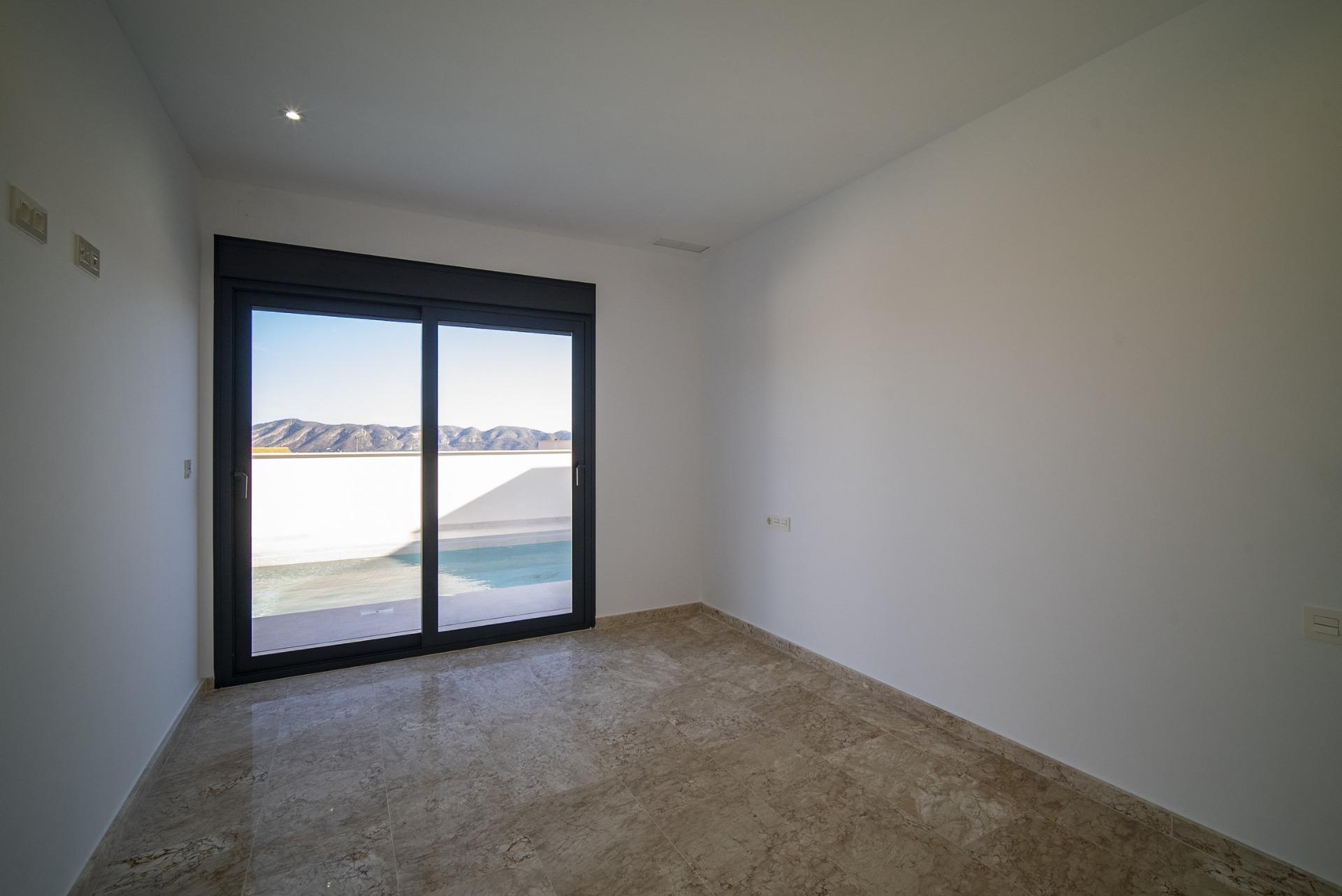Bright, modern room with polished stone floors and glass doors opening to a private pool in a new 3-bedroom villa in La Nucia, Costa Blanca.